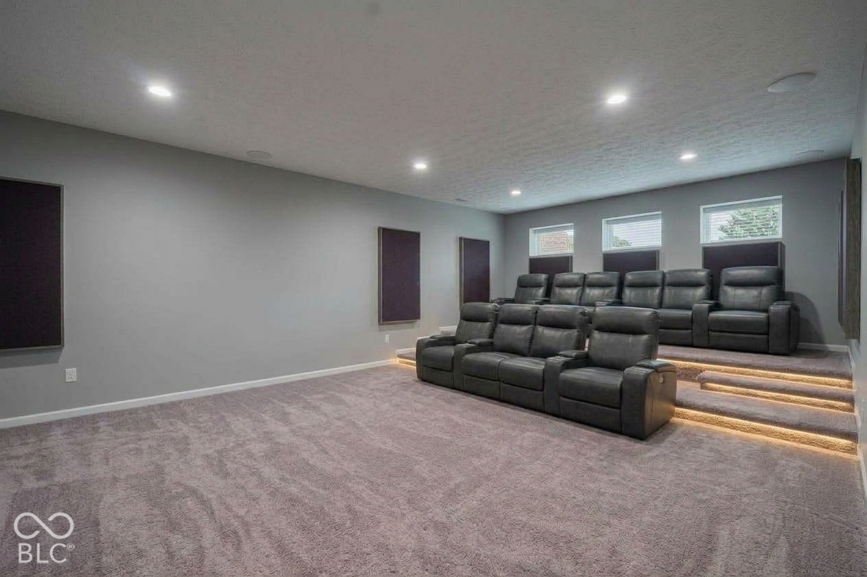 Virtually Altered - Dedicated space featuring tiered flooring, recessed stair lighting, integrated ceiling speakers, and wall-mounted acoustic panels