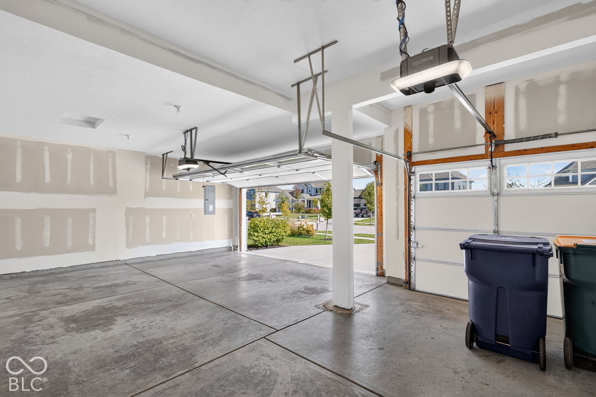 Multi-car garage featuring a concrete floor, overhead automatic door openers, and paneled garage doors with upper glass inserts