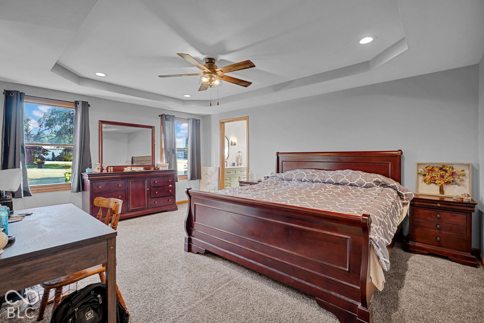 Tray ceiling featuring recessed lighting and a central ceiling fan, neutral wall tones, and carpeted flooring
