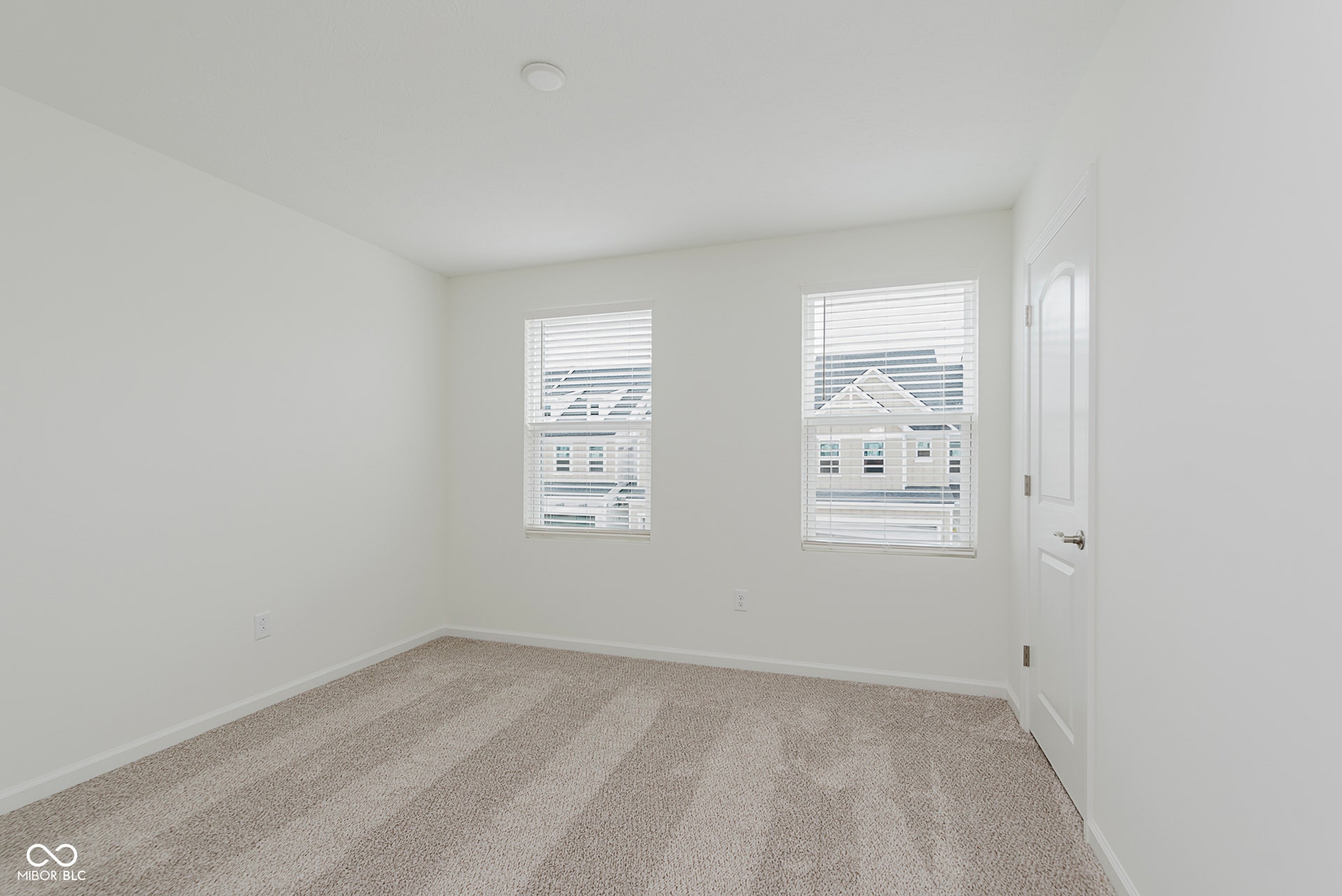 spare room with light carpet and baseboards