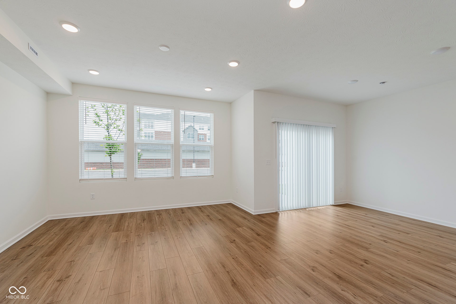 empty room with light wood-style floors and recessed lighting