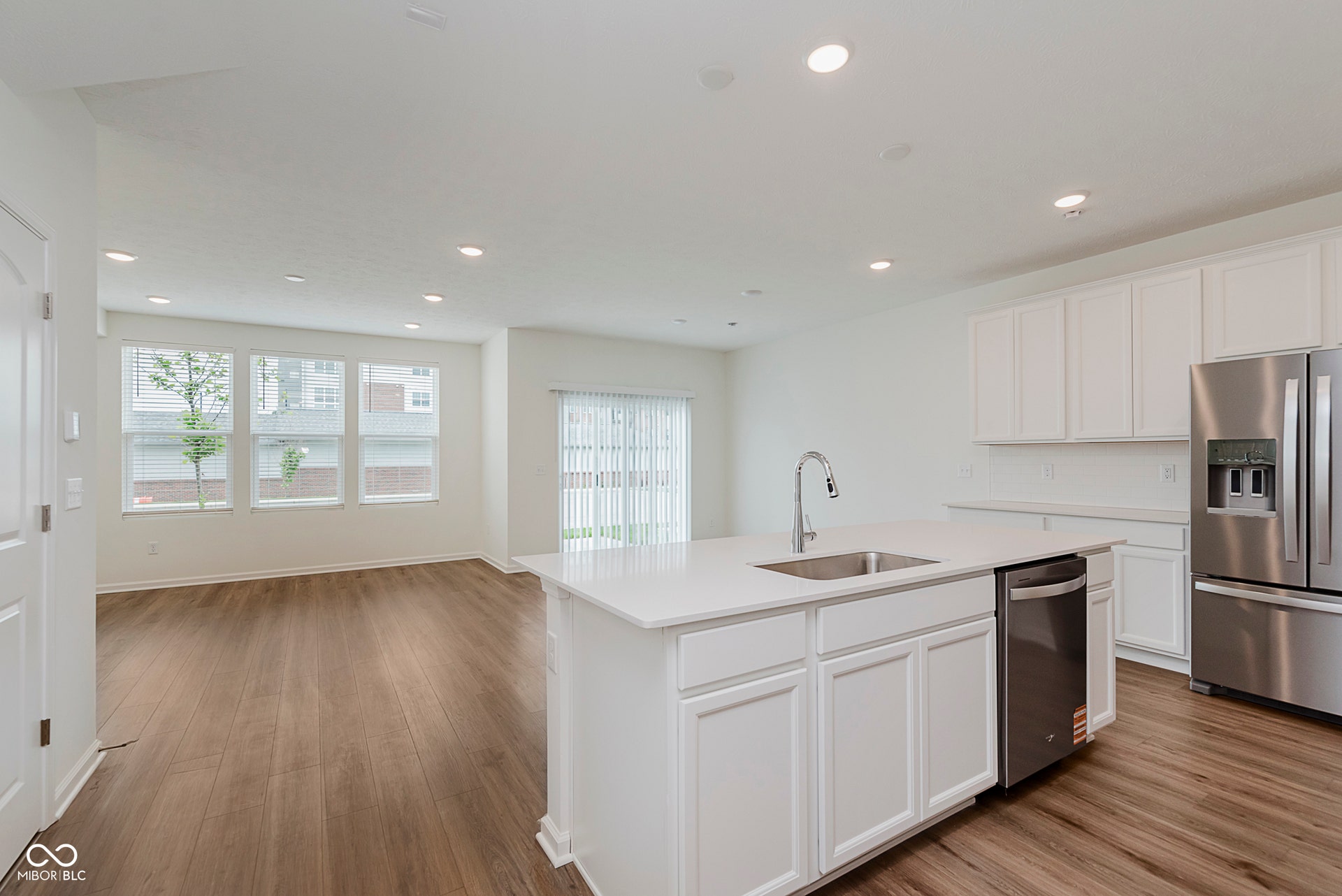 kitchen featuring white cabinetry, stainless steel appliances, recessed lighting, a center island with sink, and dark wood-type flooring