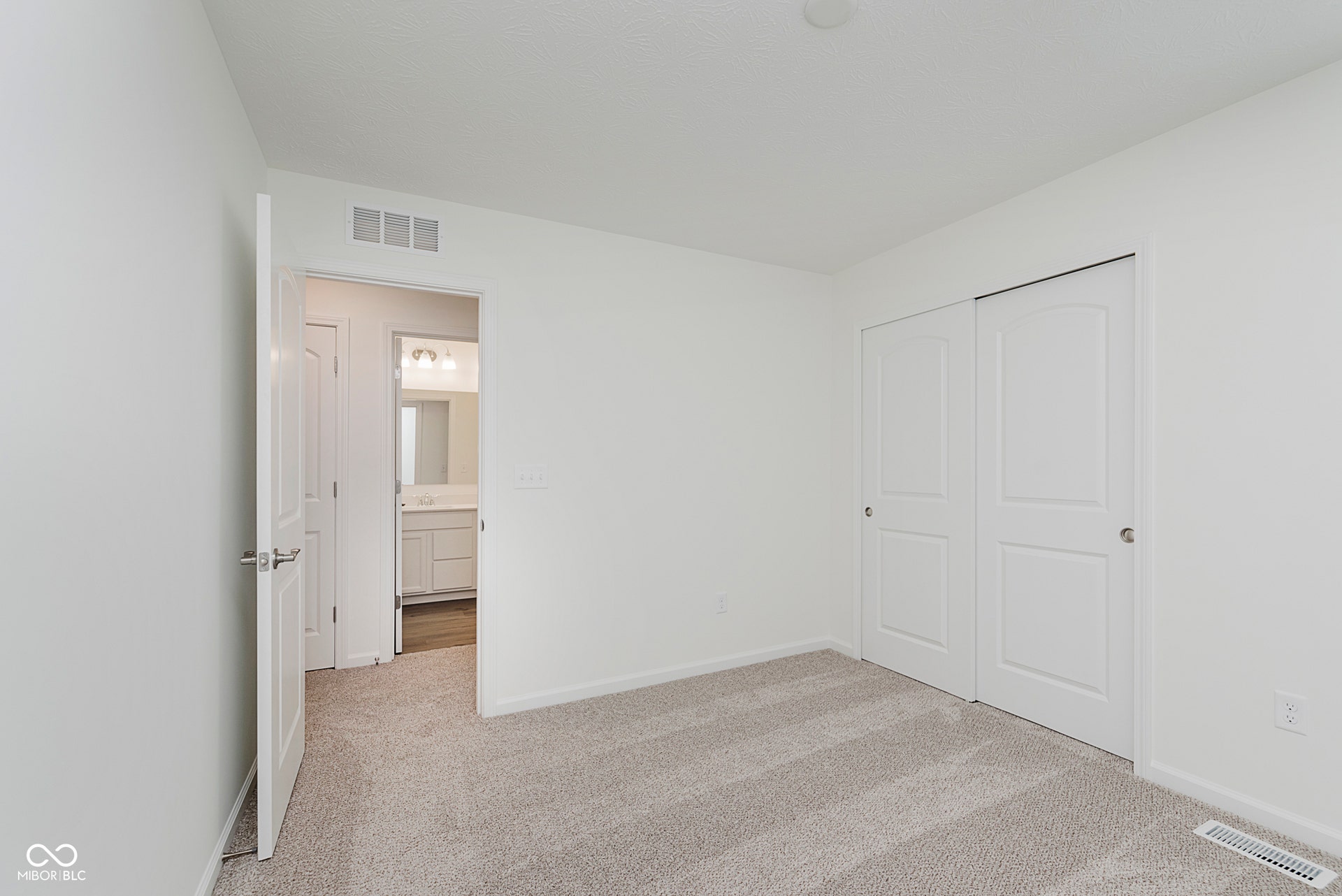 unfurnished bedroom featuring light colored carpet and a closet