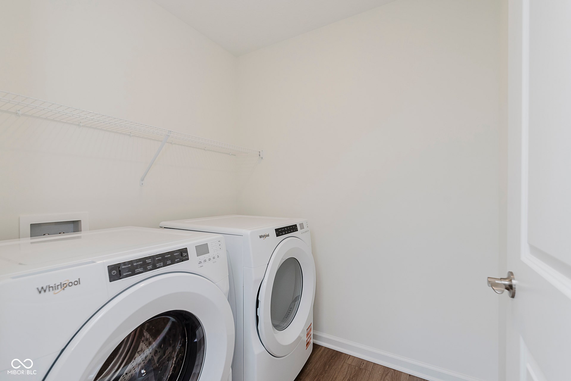 laundry room with dark wood finished floors and washing machine and clothes dryer