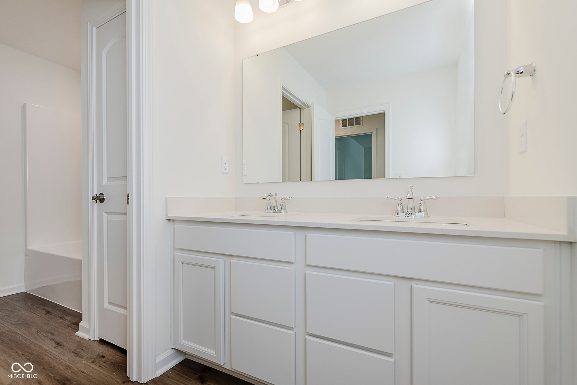 bathroom with double vanity and dark wood-style floors