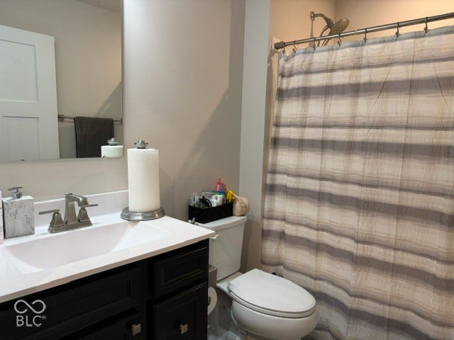 Dark-finished vanity with an integrated white sink, white countertop, chrome faucet hardware, and a wall-mounted mirror