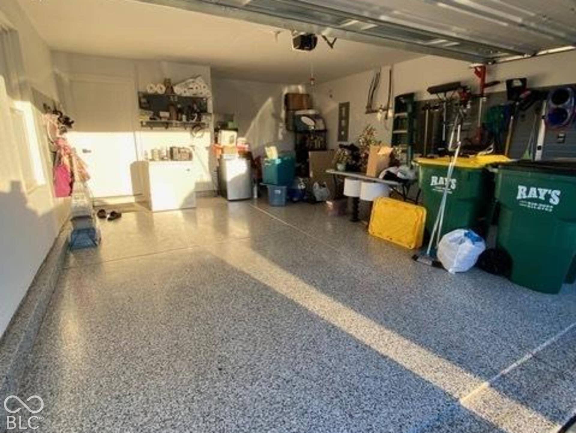 Attached garage featuring high-gloss epoxy flooring and integrated garage door opener