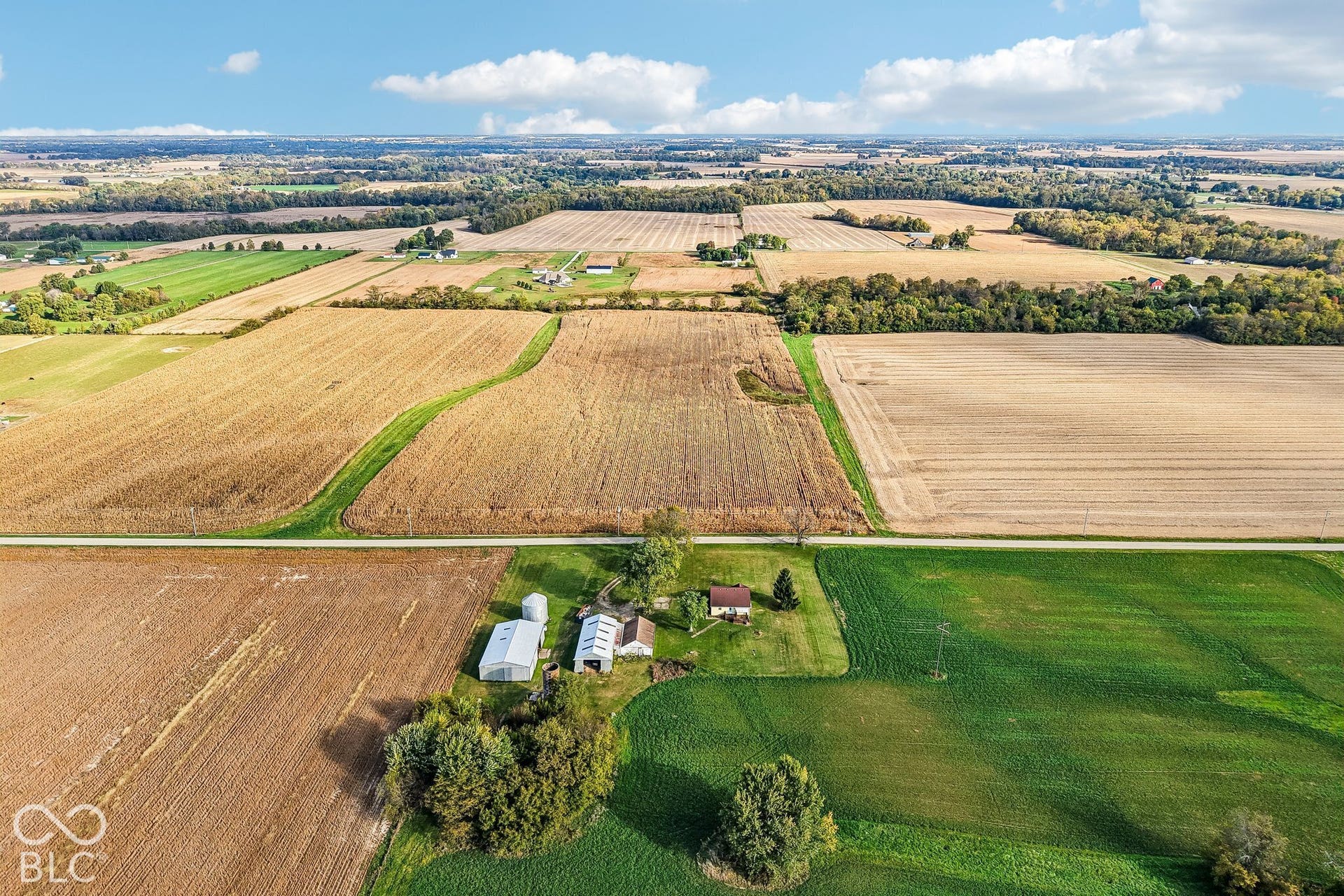 4469 E 400 S, Franklin, IN 46131 Aerial view of a sprawling property featuring extensive acreage, multiple agricultural outbuildings, and a detached residence surrounded by mature trees