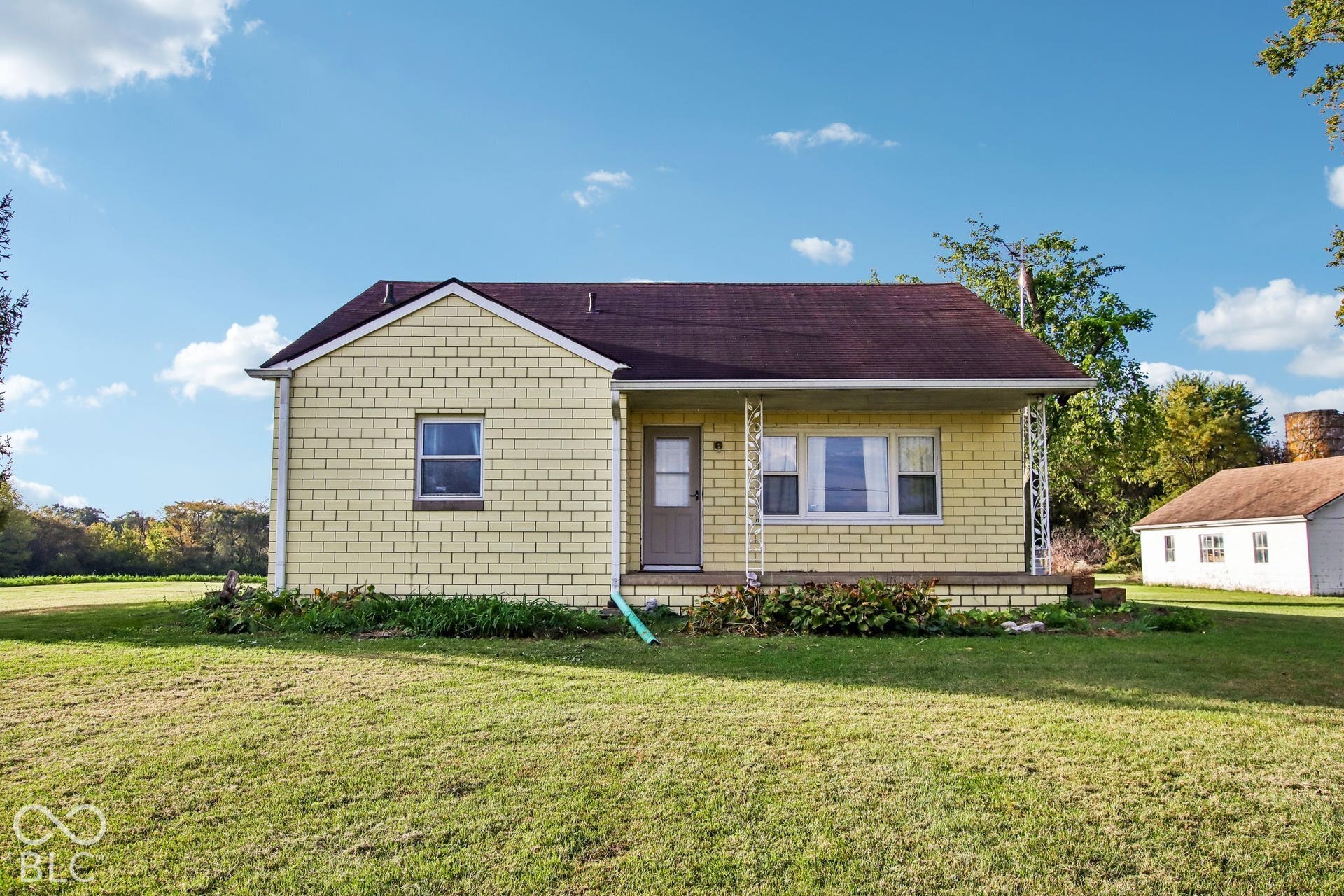 4469 E 400 S, Franklin, IN 46131 Exterior featuring light-colored masonry block siding, a covered front porch with decorative metal supports, and a shingled gable roof