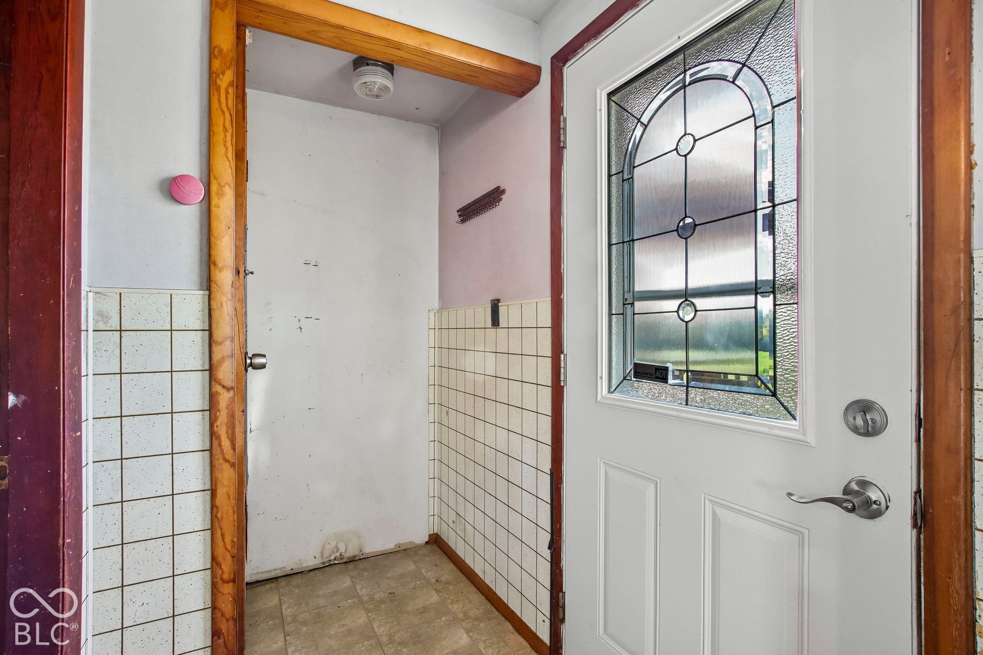 4469 E 400 S, Franklin, IN 46131 Entry area featuring a glass-inset door with decorative caming, natural wood door trim, and ceramic tile wall wainscoting
