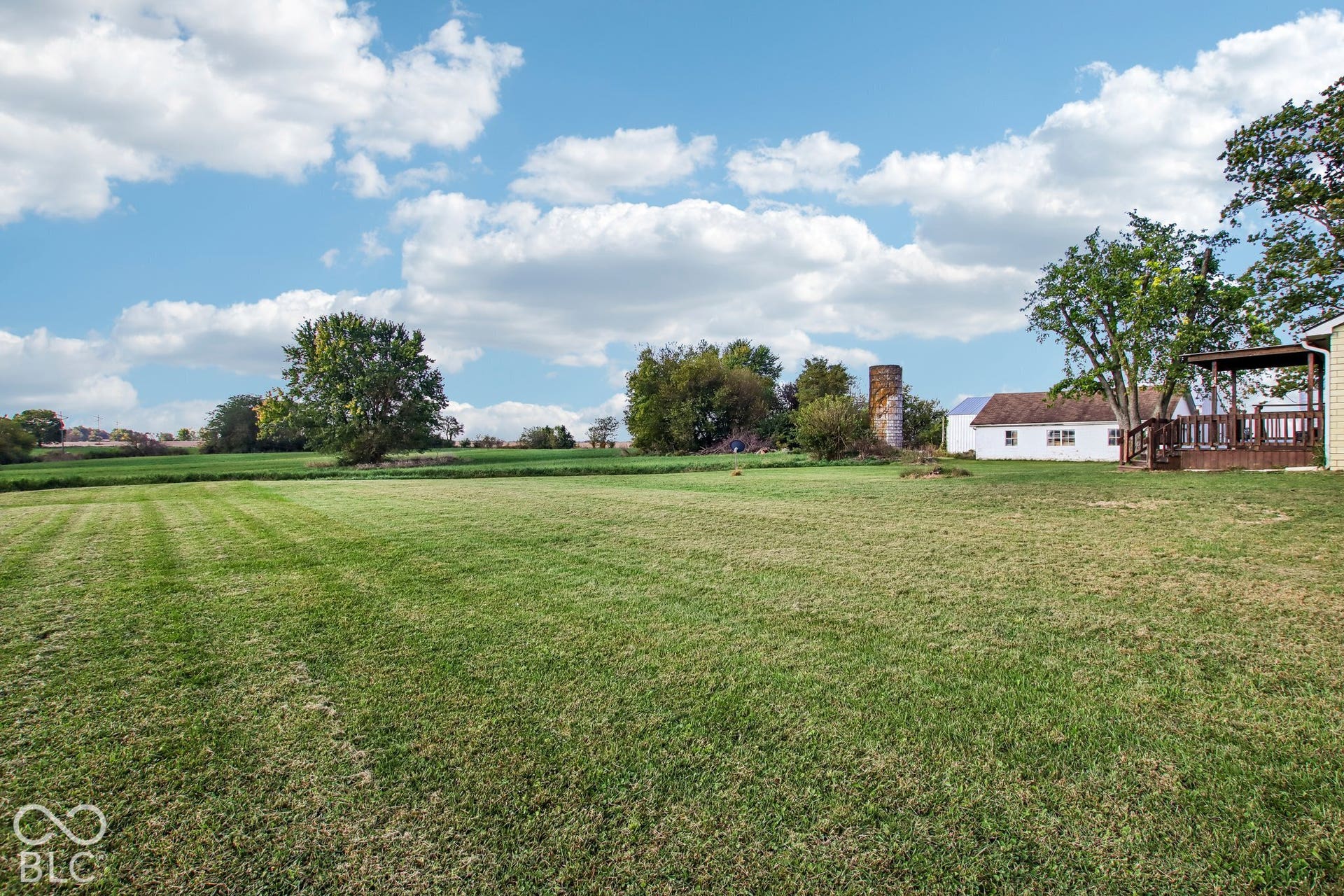 4469 E 400 S, Franklin, IN 46131 Expansive grounds featuring a vast lawn, mature trees, a detached outbuilding, and a prominent silo