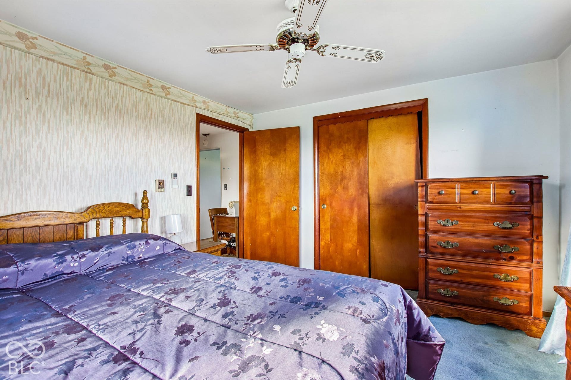 4469 E 400 S, Franklin, IN 46131 Room featuring textured wallpaper, natural wood-finish interior doors, a double-door closet with wood-finish doors, and a ceiling fan with integrated lighting