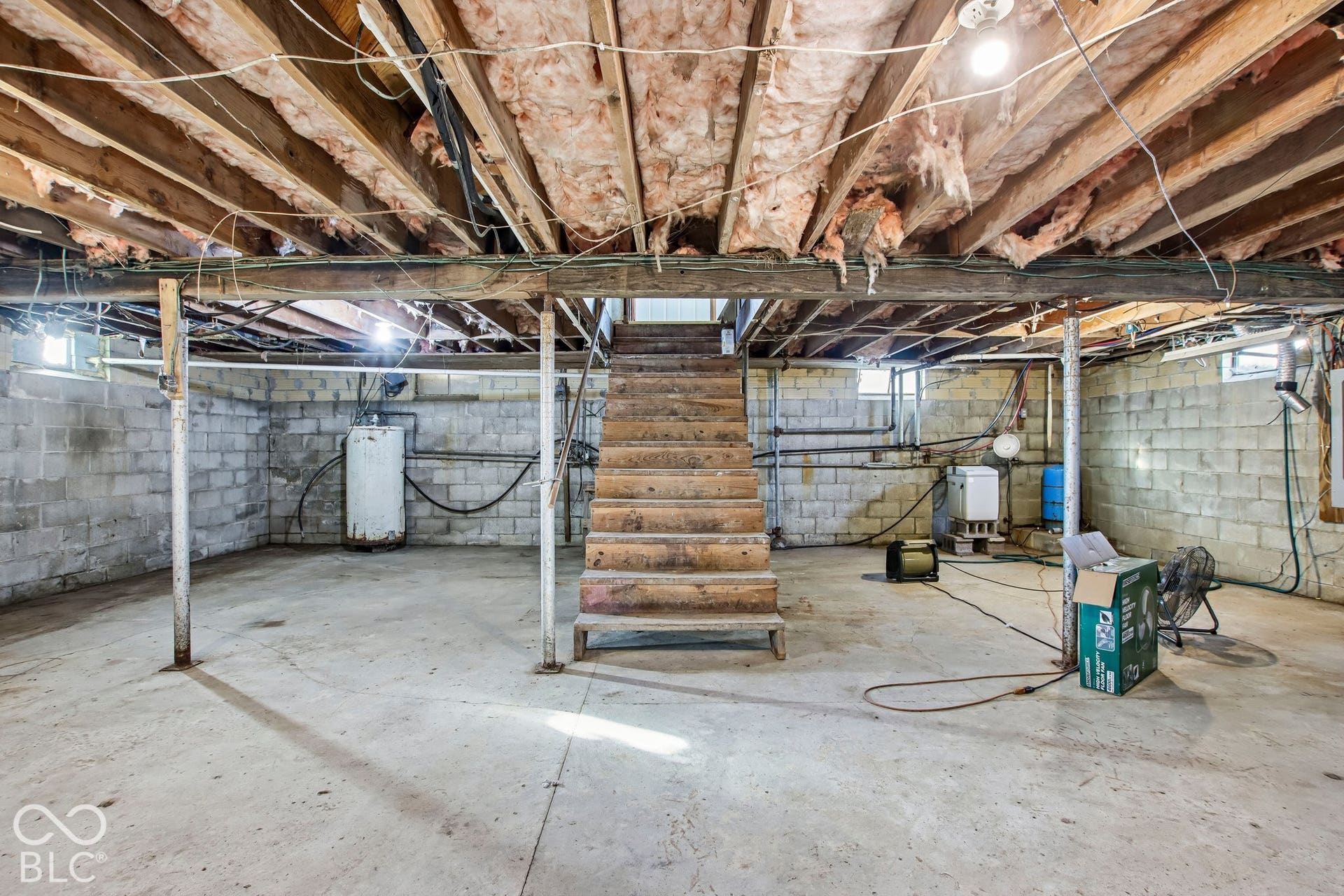 4469 E 400 S, Franklin, IN 46131 Unfinished lower level featuring concrete block walls, a concrete floor, exposed wooden joists, and a central wooden staircase