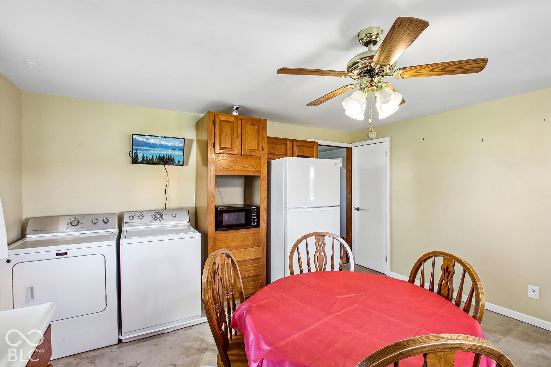 4469 E 400 S, Franklin, IN 46131 Custom-built wood cabinetry, white top-load laundry appliances, full-size refrigerator, and multi-light ceiling fan with wood-finish blades