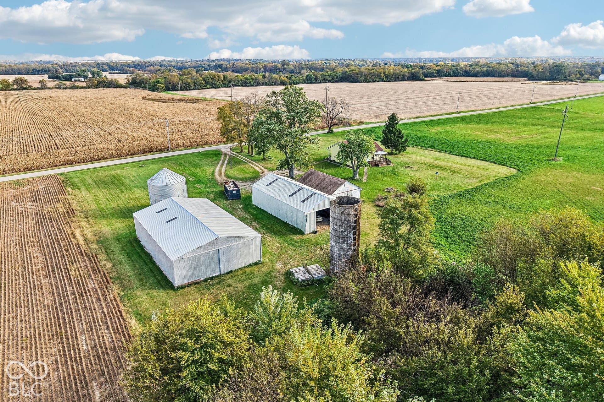 4469 E 400 S, Franklin, IN 46131 Aerial view of rural property featuring multiple metal-sided outbuildings, a detached silo, and expansive acreage