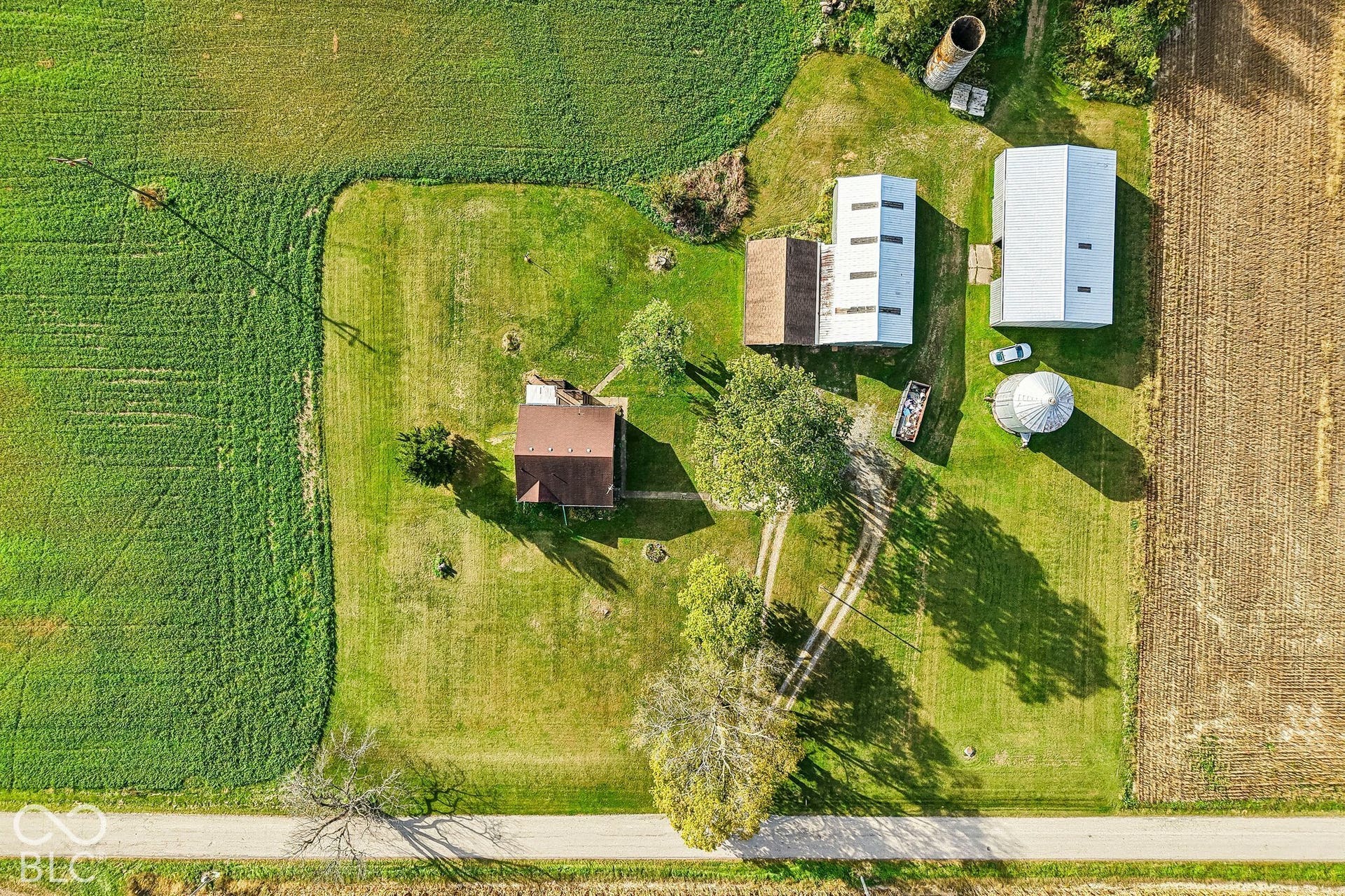 4469 E 400 S, Franklin, IN 46131 Aerial perspective of property featuring a detached residence, multi-purpose outbuildings, a metal grain silo, and expansive grounds surrounded by agricultural fields