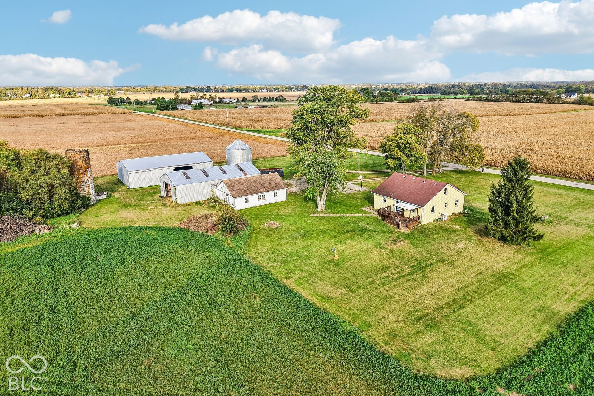 4469 E 400 S, Franklin, IN 46131 Aerial perspective of a multi-structure property featuring a detached residence, auxiliary barns, a silo, and expansive acreage