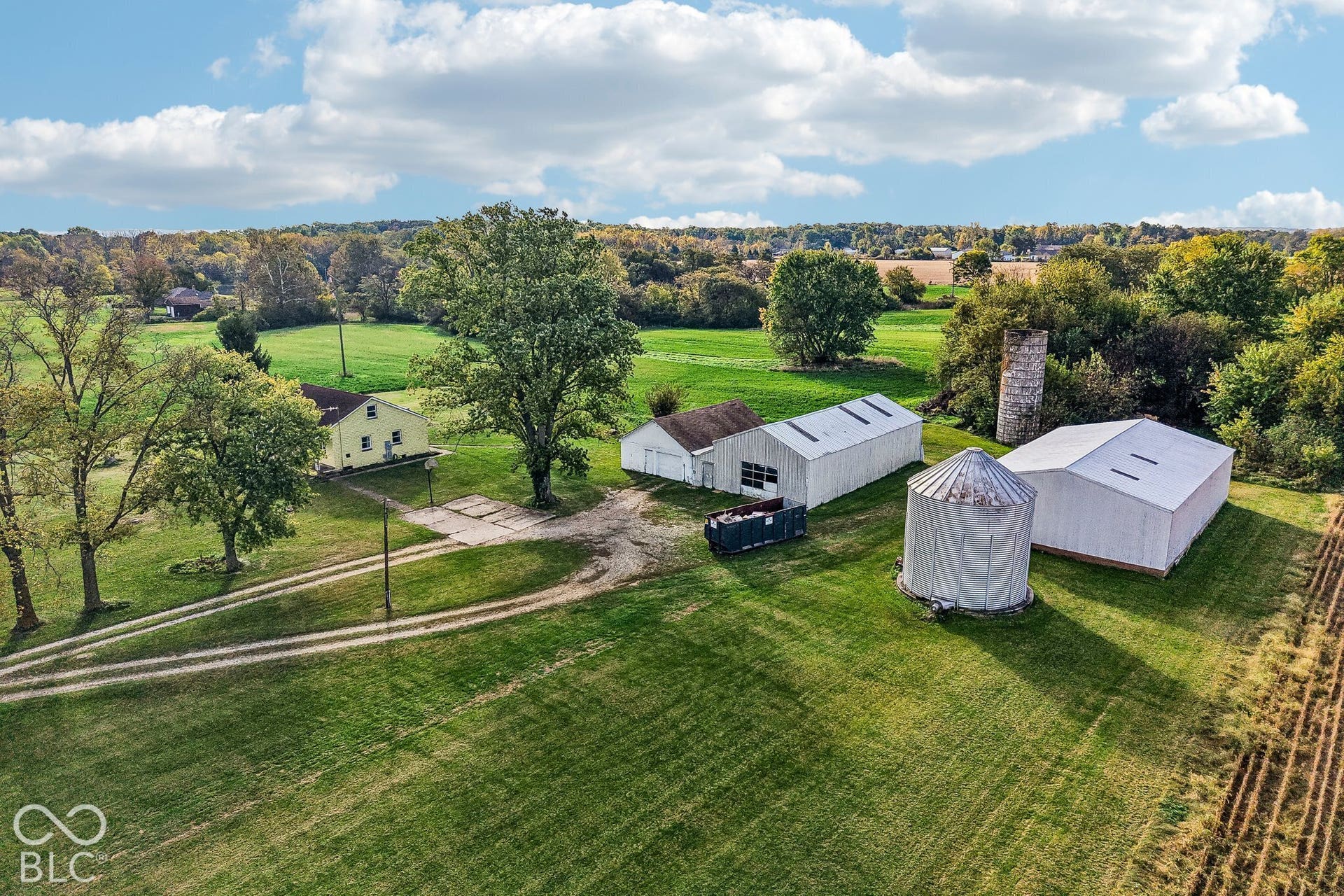 4469 E 400 S, Franklin, IN 46131 Expansive rural acreage featuring a residential structure, multiple outbuildings, grain bins, and established mature trees