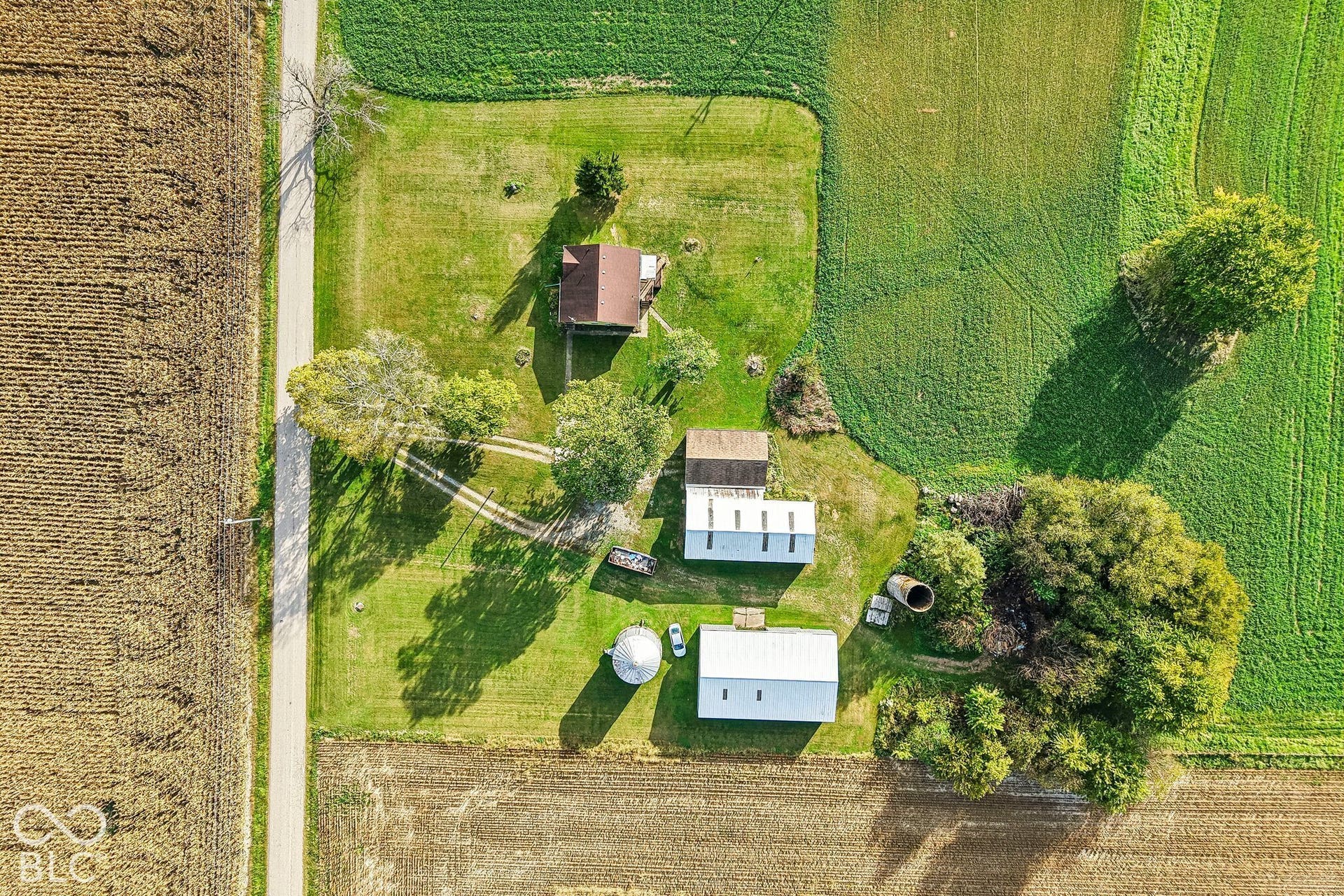 4469 E 400 S, Franklin, IN 46131 Aerial perspective of a multi-structure property featuring expansive acreage, a residential building, two metal outbuildings, and a silo