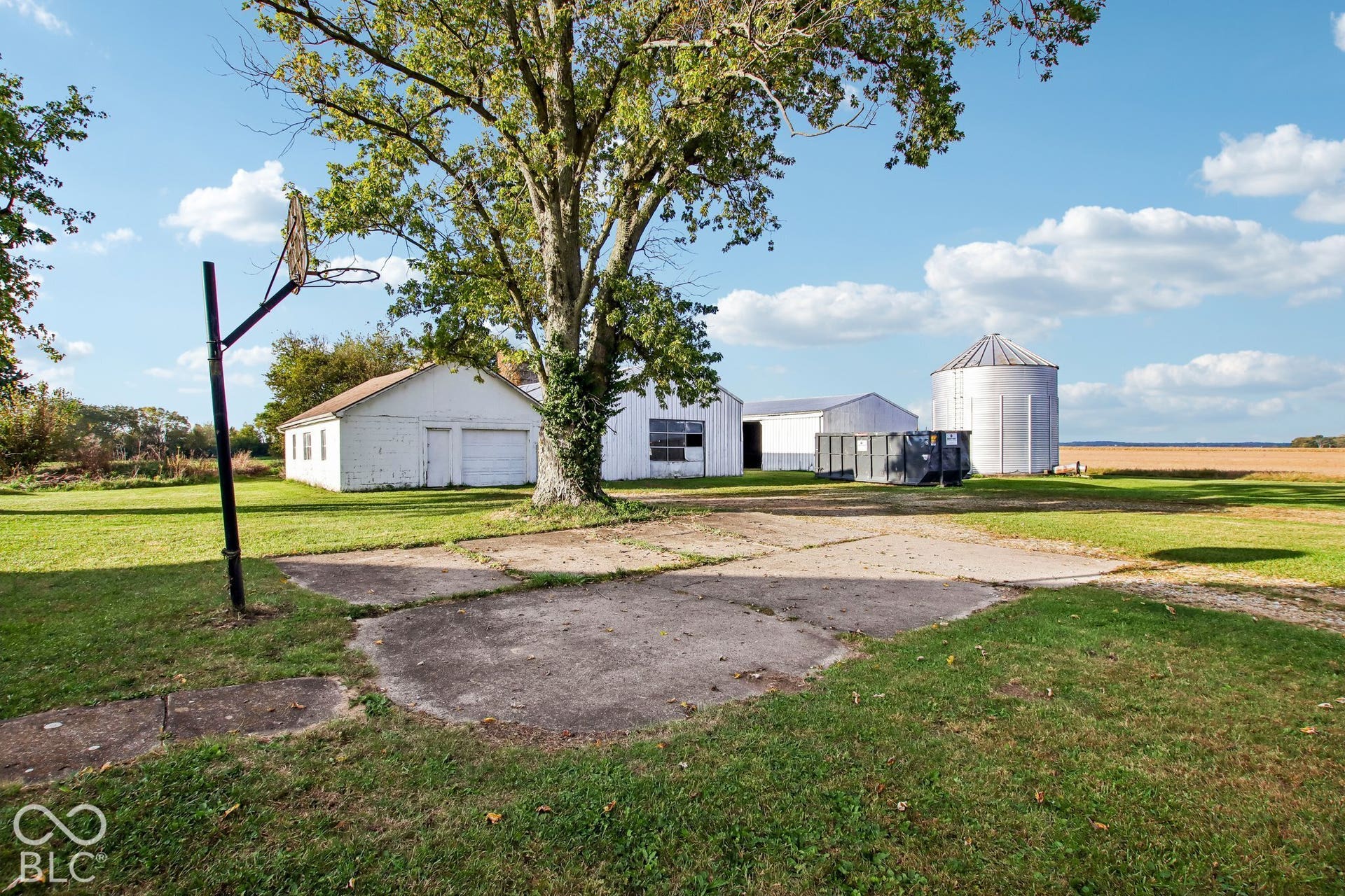 4469 E 400 S, Franklin, IN 46131 Expansive exterior grounds featuring multiple outbuildings, a metal grain silo, mature shade trees, and a concrete pad