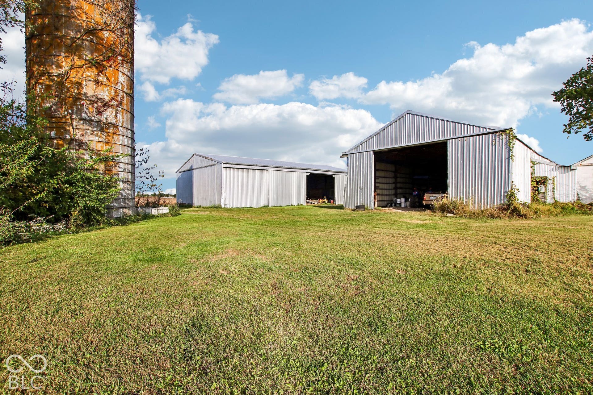 4469 E 400 S, Franklin, IN 46131 Expansive grounds featuring two metal-sided outbuildings and a weathered cylindrical silo