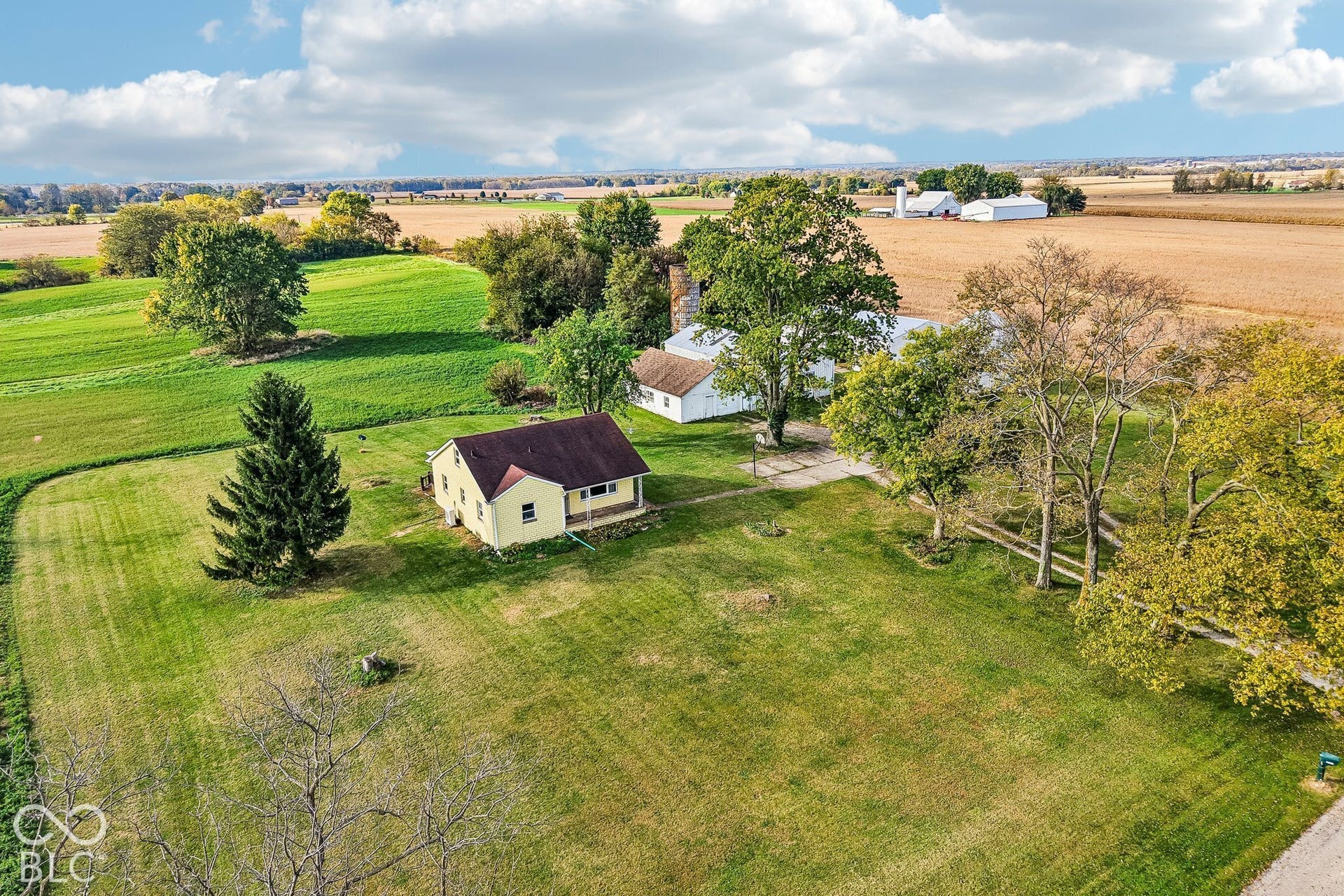 4469 E 400 S, Franklin, IN 46131 Expansive acreage featuring a single-story residence, multiple outbuildings, a concrete pad, and mature trees