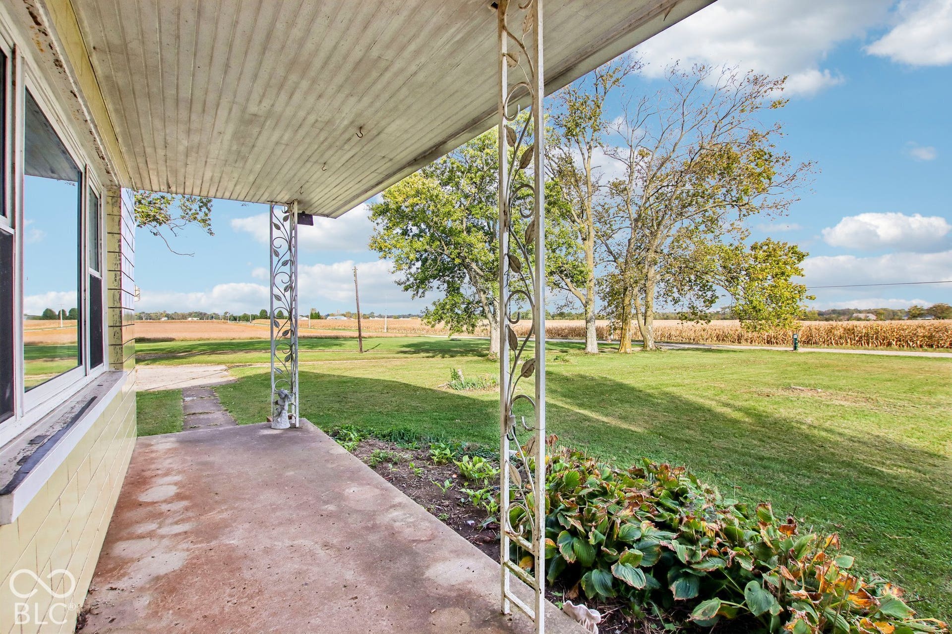 4469 E 400 S, Franklin, IN 46131 Covered porch featuring ornamental metal support columns, concrete flooring, and unobstructed landscape surroundings