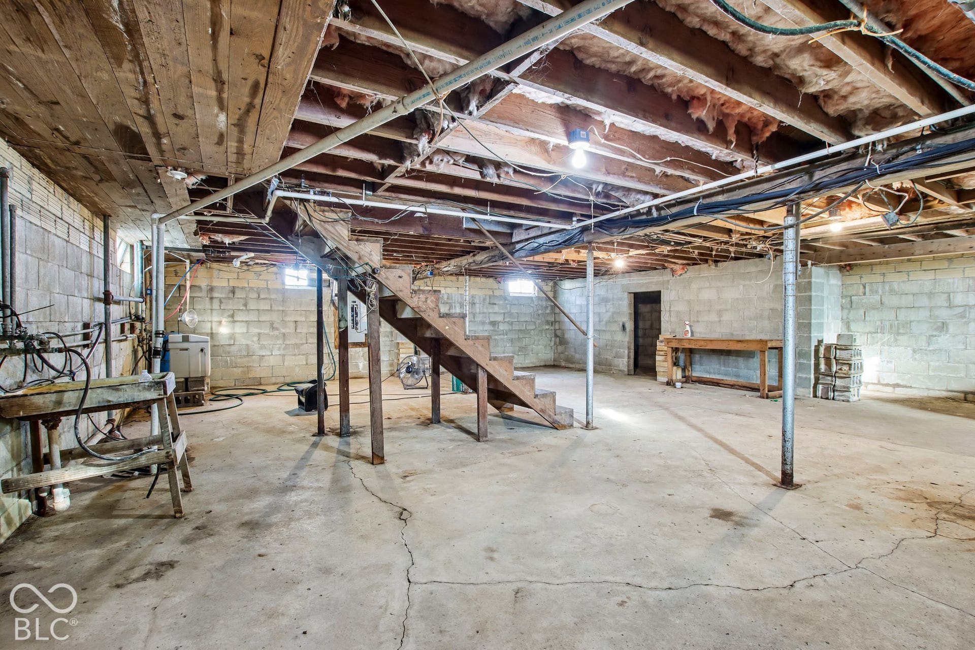 4469 E 400 S, Franklin, IN 46131 Unfinished lower level featuring concrete block walls, concrete flooring, exposed wooden joists, and a wooden staircase