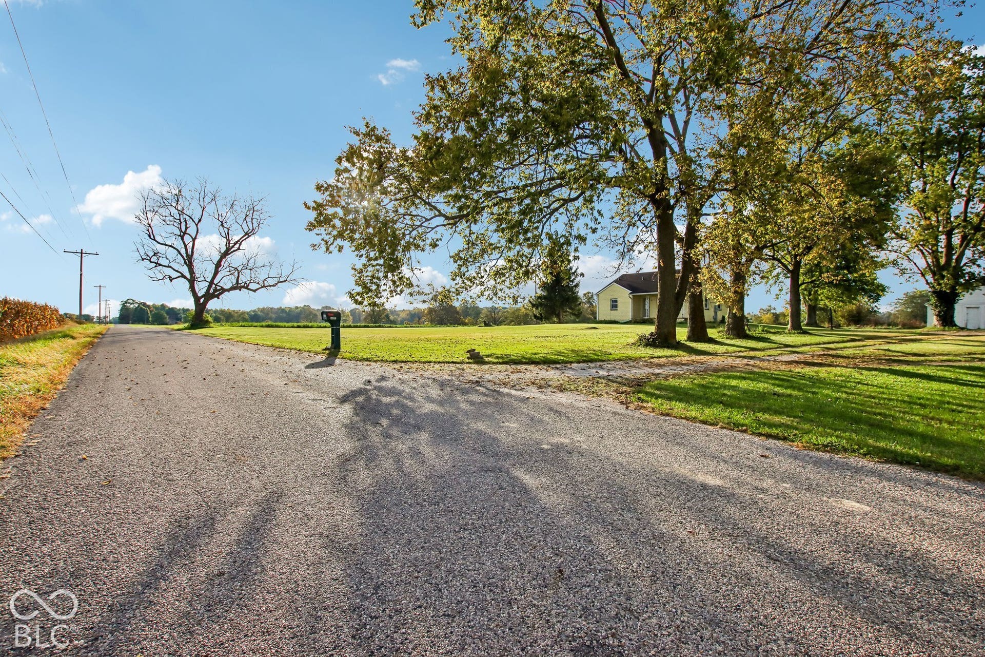 4469 E 400 S, Franklin, IN 46131 Expansive acreage featuring a gravel driveway, mature trees, and open lawn space