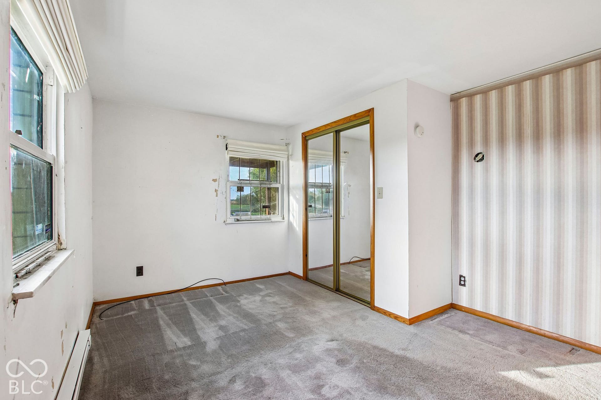 4469 E 400 S, Franklin, IN 46131 Room featuring dual windows, floor-to-ceiling mirrored sliding closet doors, and vertical striped wall covering