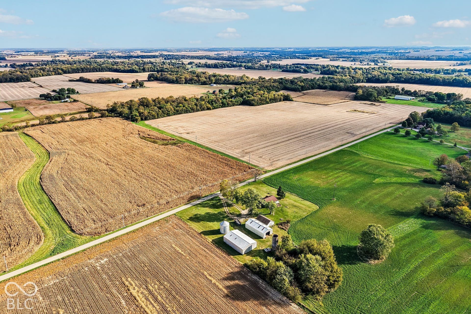 4469 E 400 S, Franklin, IN 46131 Expansive acreage featuring cultivated agricultural fields, mature tree lines, two metal-sided outbuildings, and a silo