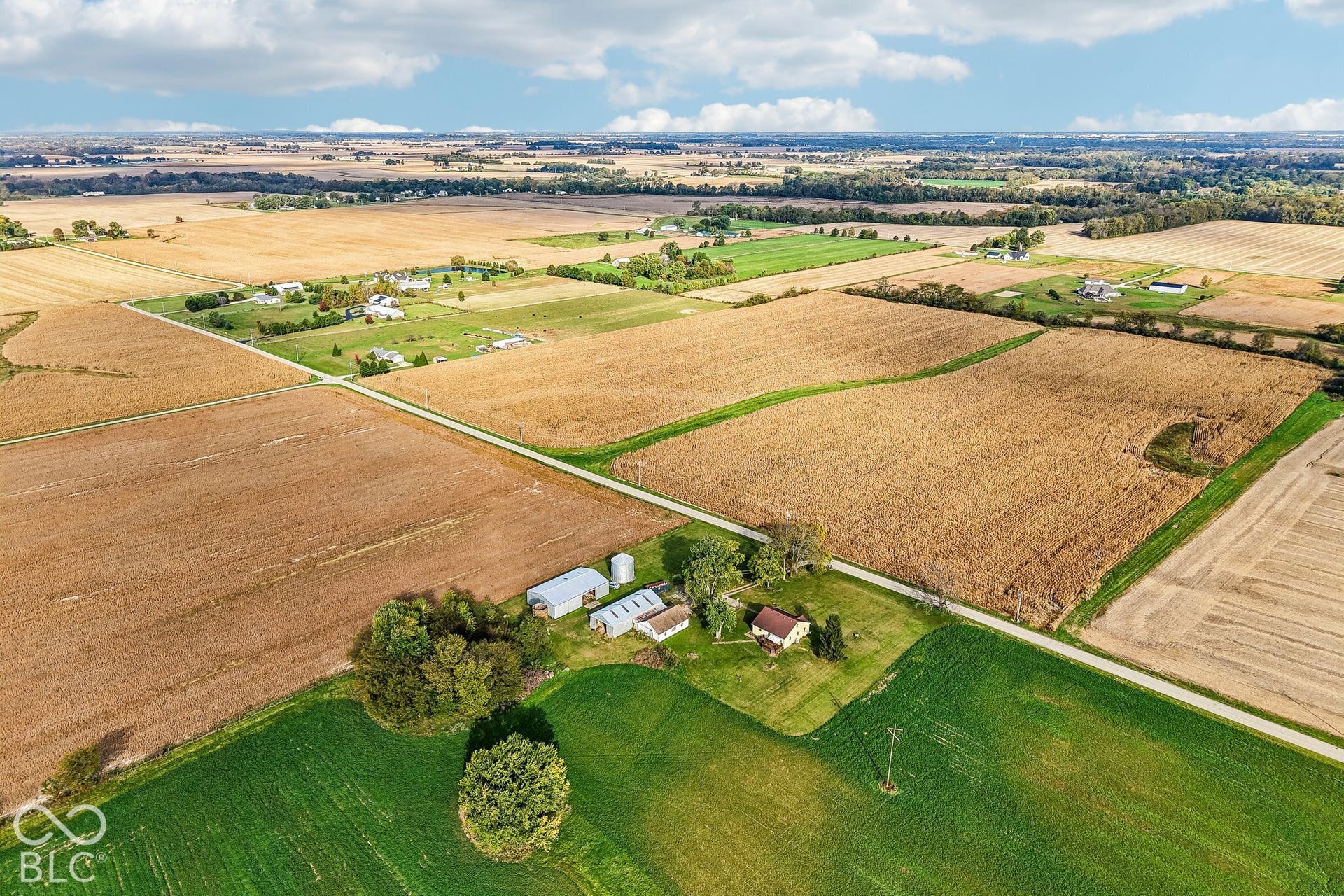 4469 E 400 S, Franklin, IN 46131 Aerial perspective of a sprawling rural property featuring expansive acreage, multiple outbuildings, a silo, and mature trees