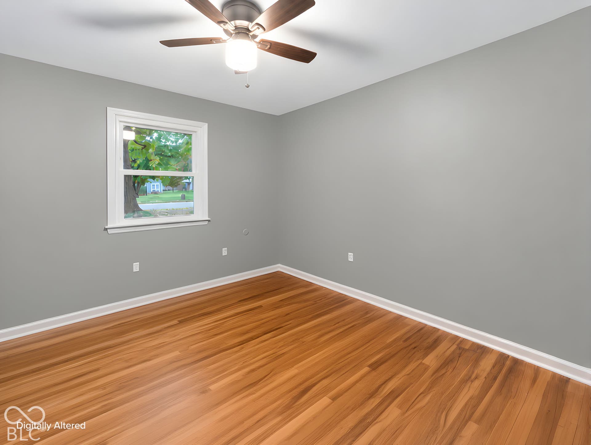 Neutral-toned interior walls featuring wood-finish flooring, a single-hung window, and a ceiling-mounted light fixture with a fan