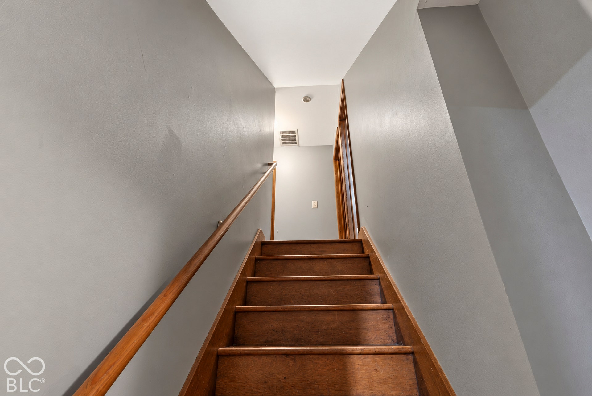 Staircase featuring wood treads, risers, and matching handrails