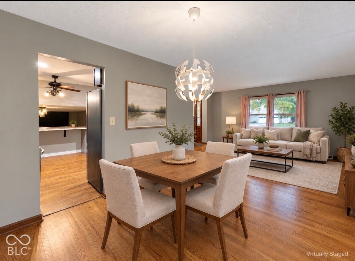 Virtually Altered - Open-concept interior featuring wood-finish flooring, a modern spherical pendant light fixture, and large windows