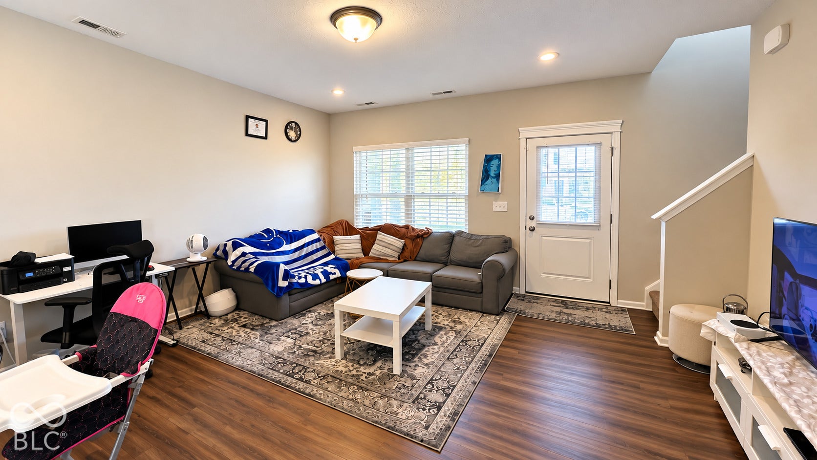 Living space featuring wood-finish flooring, recessed lighting, a flush-mount ceiling fixture, and a neutral color palette