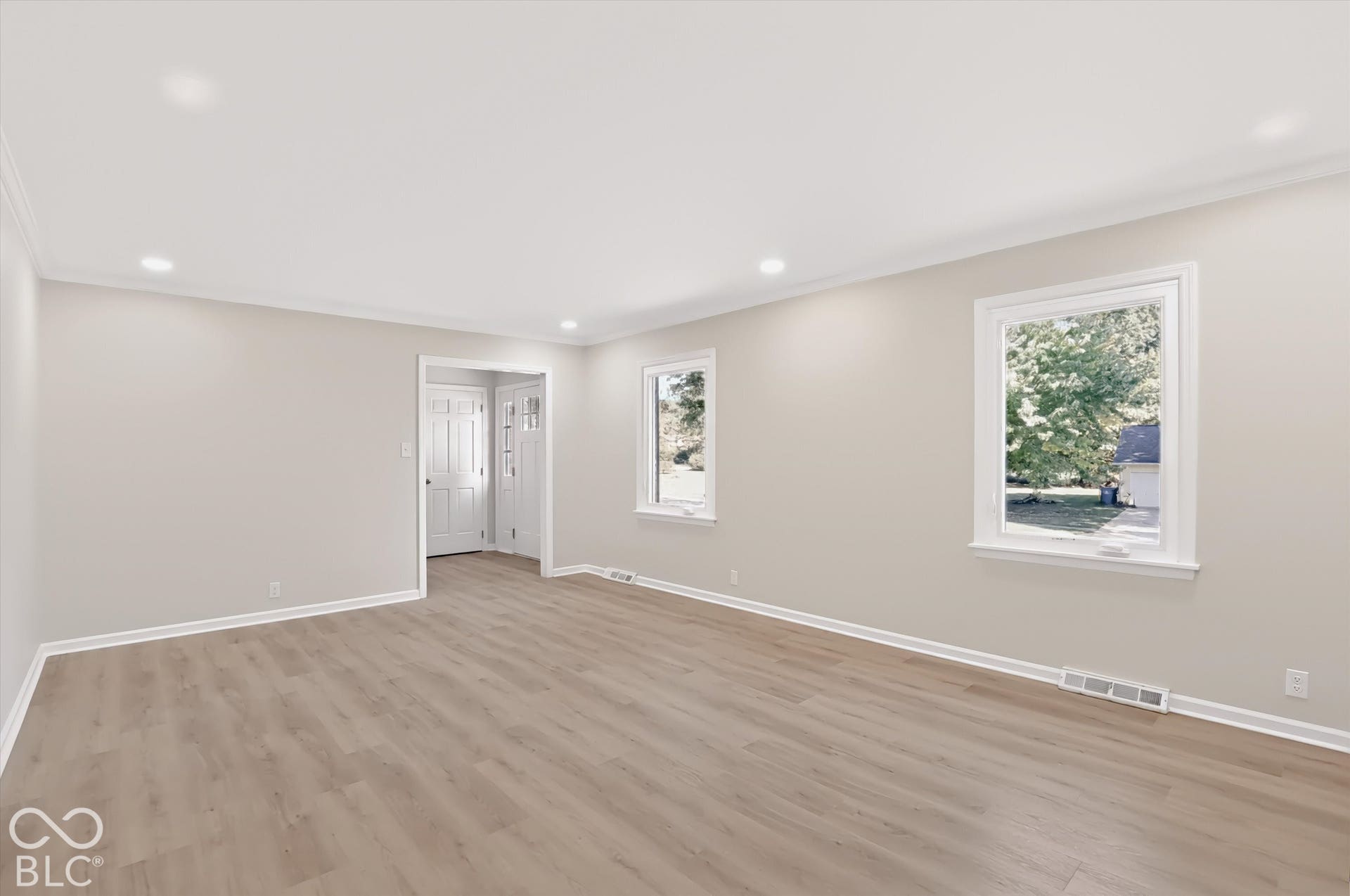 Neutral interior featuring wood-finish flooring, recessed lighting, and multiple windows