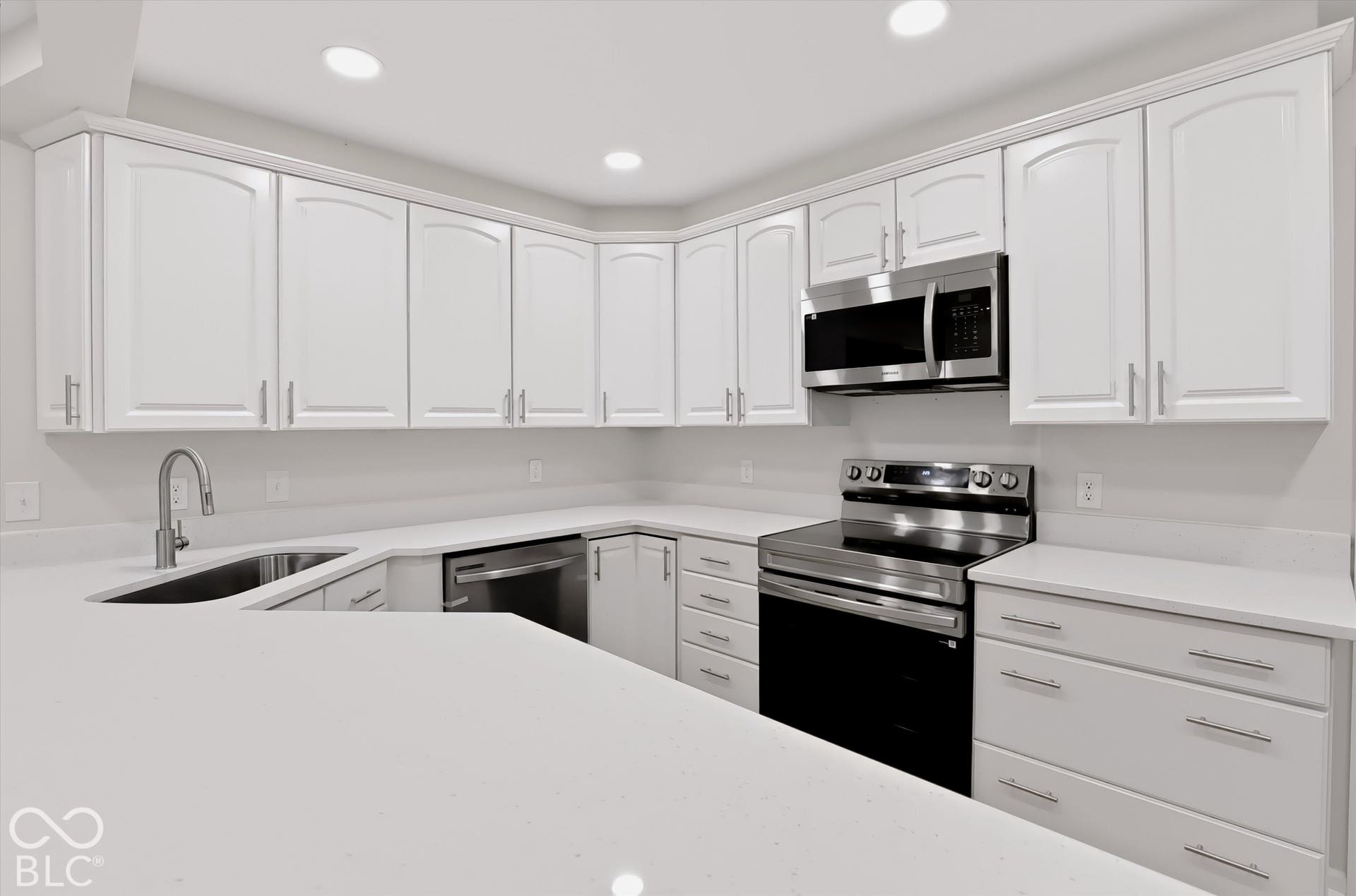 Kitchen featuring white cabinetry, quartz countertops, stainless steel appliances, and recessed lighting