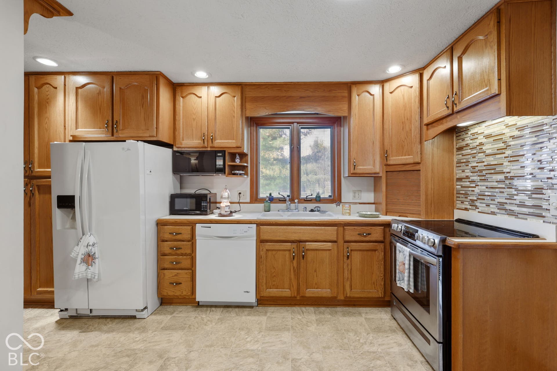 280 Anniston, Indianapolis, IN 46227 Kitchen featuring stained wood cabinetry, a decorative multi-tone tile backsplash, recessed ceiling lighting, and a stainless steel range