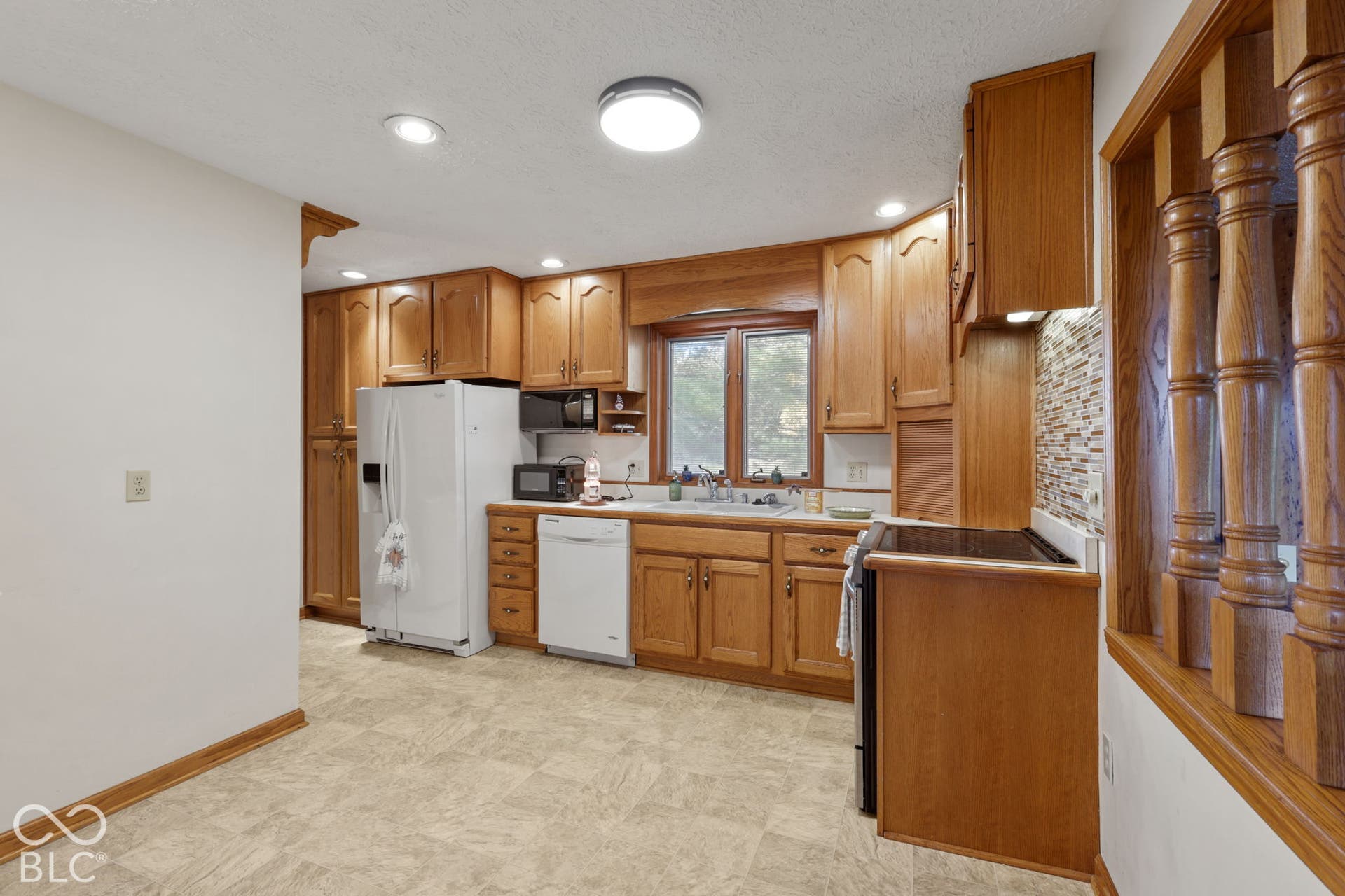 280 Anniston, Indianapolis, IN 46227 Kitchen featuring wood cabinetry, recessed lighting, tile backsplash, and a double-basin sink