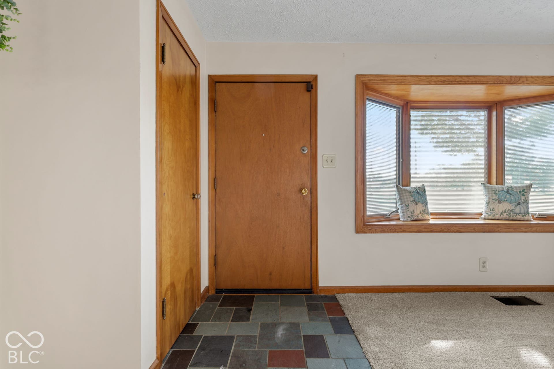 280 Anniston, Indianapolis, IN 46227 Entryway featuring multi-toned slate flooring, wood-grain door, built-in closet, and bay window with wood trim