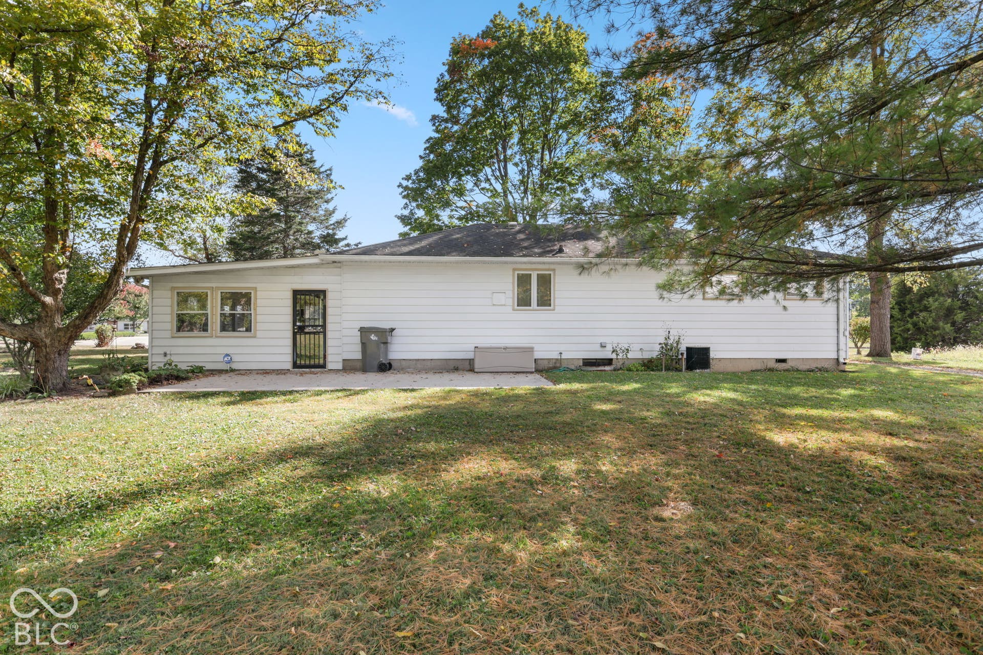 280 Anniston, Indianapolis, IN 46227 Exterior profile featuring light-colored horizontal siding, a paved patio, and mature trees on a spacious lot