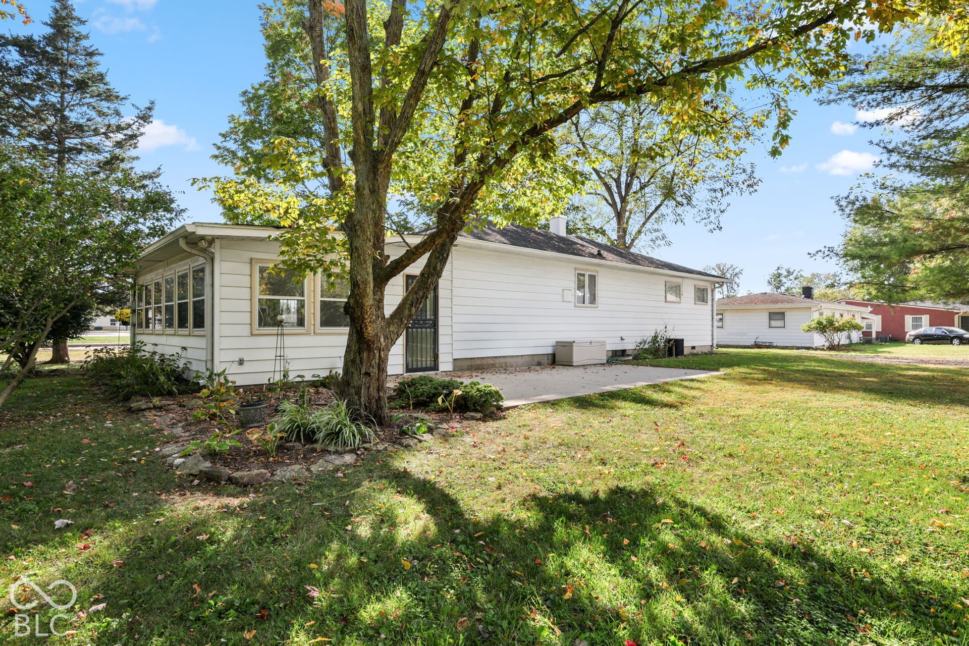 280 Anniston, Indianapolis, IN 46227 Rear exterior featuring white horizontal siding, a concrete patio, a screened enclosure, and mature trees