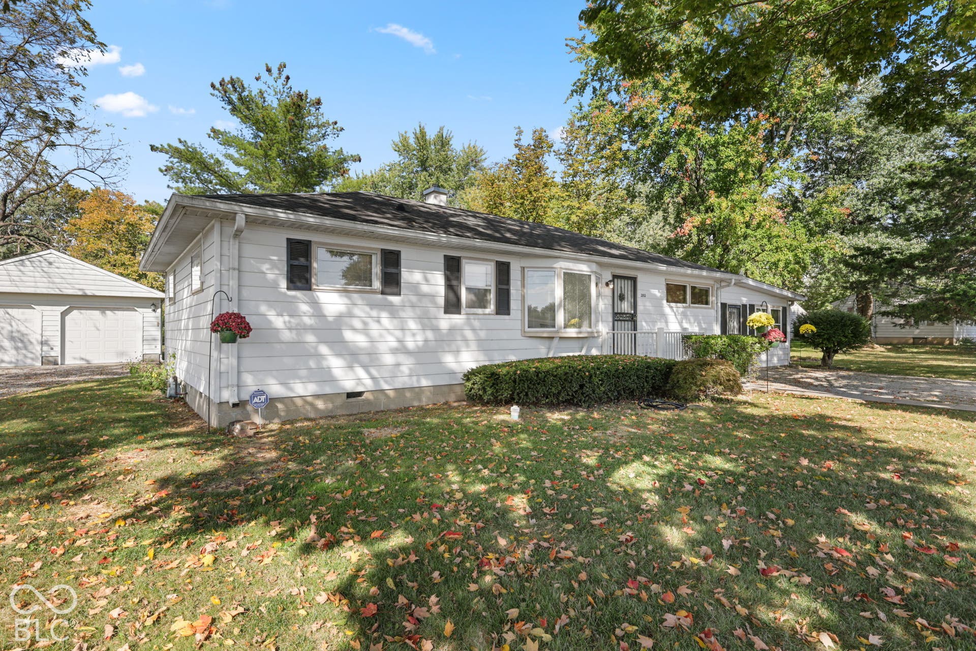 280 Anniston, Indianapolis, IN 46227 Single-story residence featuring white horizontal siding, a bay window, black shutters, a concrete driveway, and a detached two-car garage