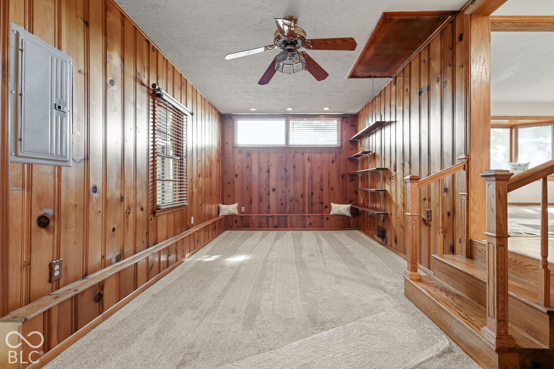 280 Anniston, Indianapolis, IN 46227 Vertical wood paneling, wall-mounted wood shelving, carpeted flooring, transom windows, and a ceiling fan with integrated lighting