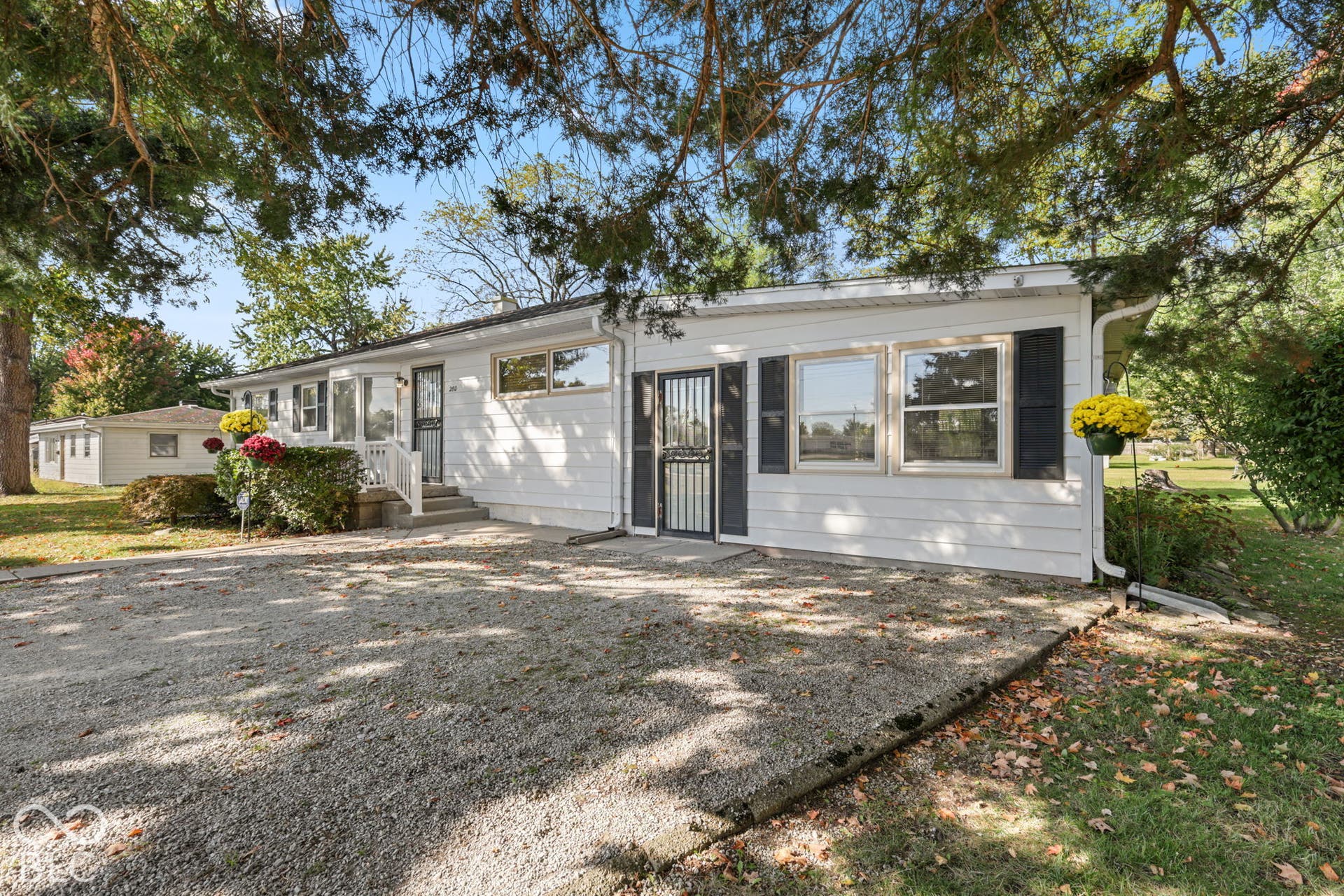 280 Anniston, Indianapolis, IN 46227 Ranch-style exterior featuring white horizontal siding, dark decorative shutters, a gravel driveway, and a front entry with a security door