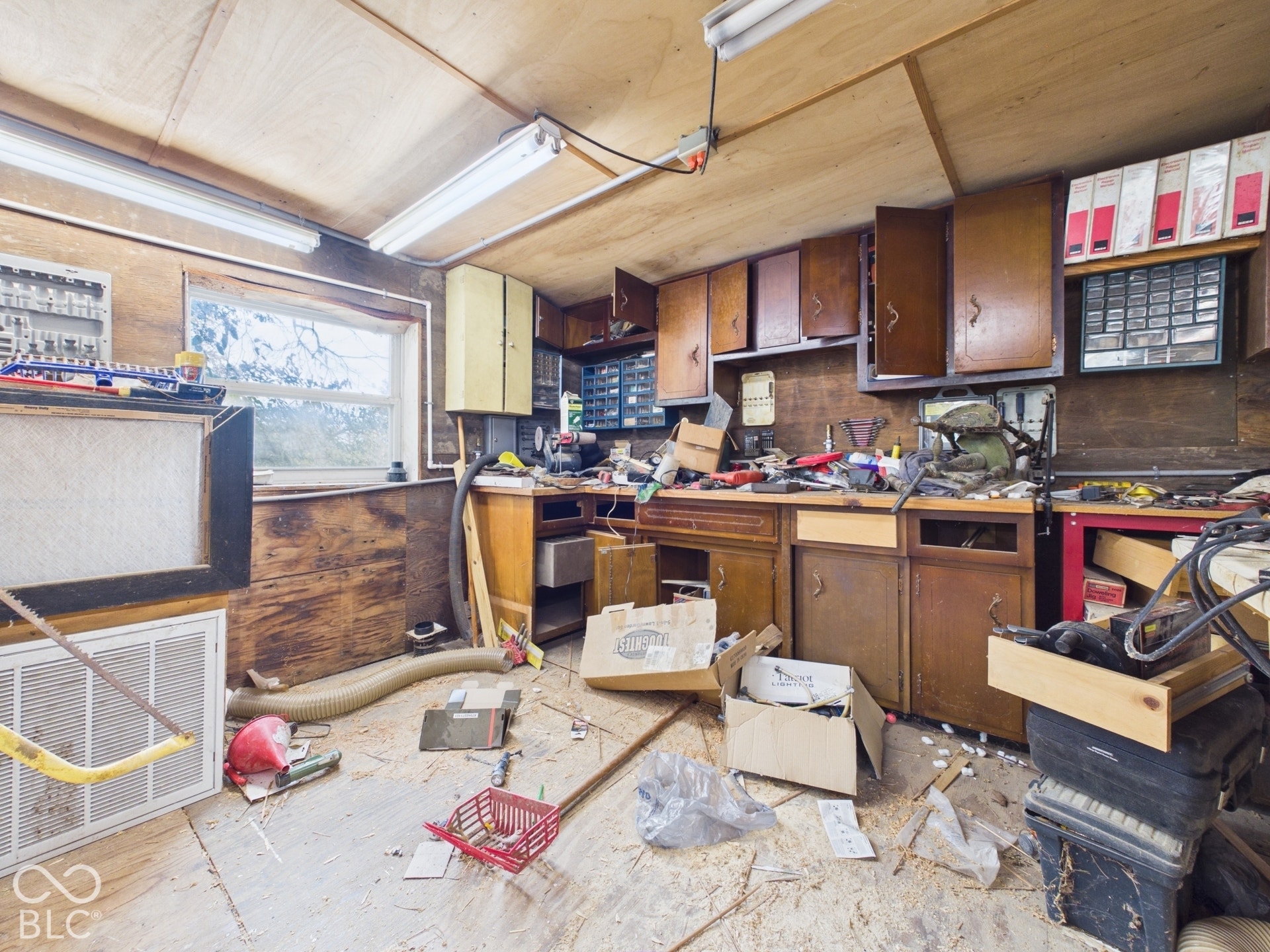 Workshop area featuring wood-panelled walls, built-in cabinetry, and integrated linear lighting
