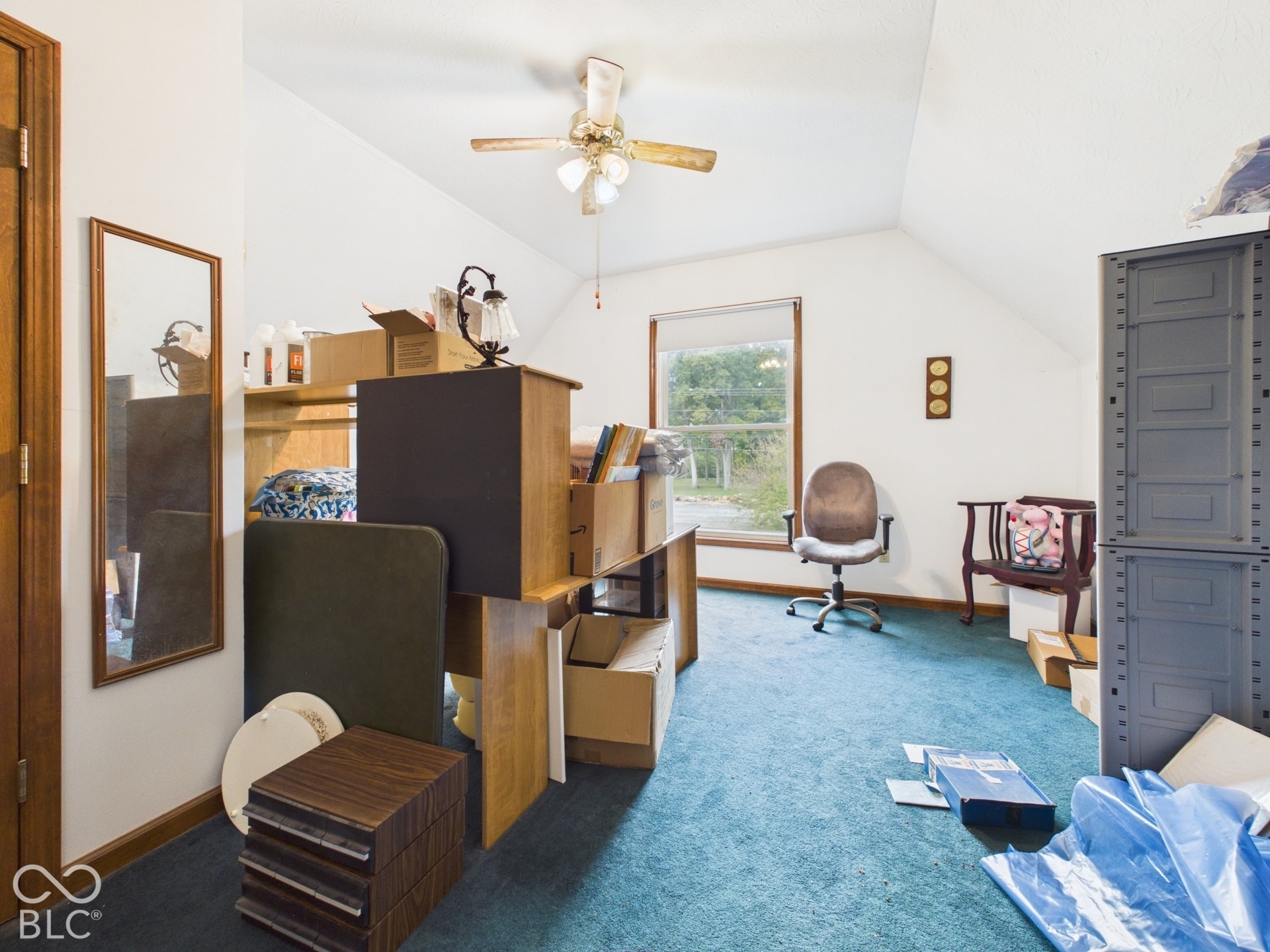 Vaulted ceiling, wall-to-wall carpeting, window with natural lighting, and ceiling fan with integrated light fixture