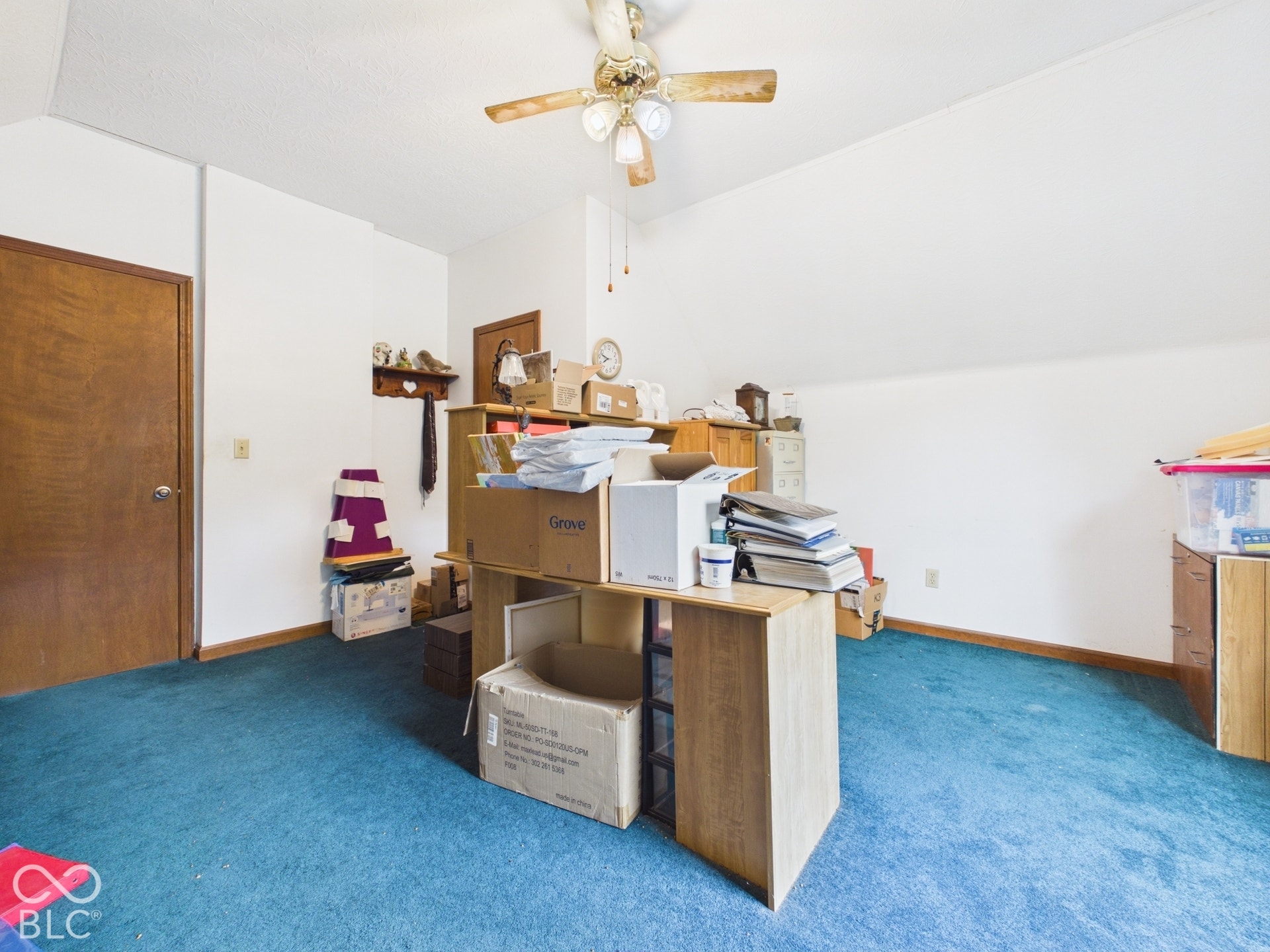 Vaulted ceiling with a centrally mounted lighted ceiling fan and wall-to-wall carpeting