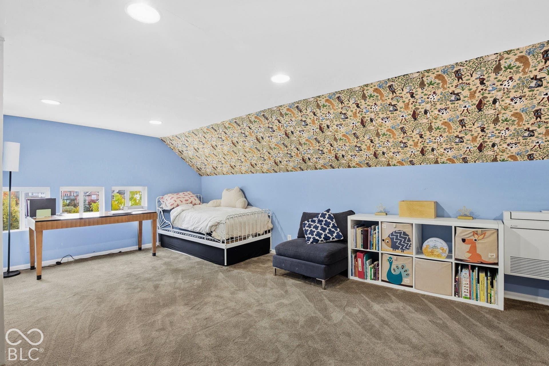 Vaulted ceiling with patterned wall covering, carpeted flooring, and recessed lighting